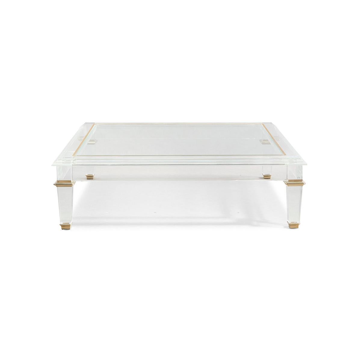 French Neo Classic 18th-century inspired design with clean and classic lines, this cocktail table comes to life in crisp acrylic.

The table’s surface features a glass top and the tapered acrylic legs are accentuated with polished brass collars and