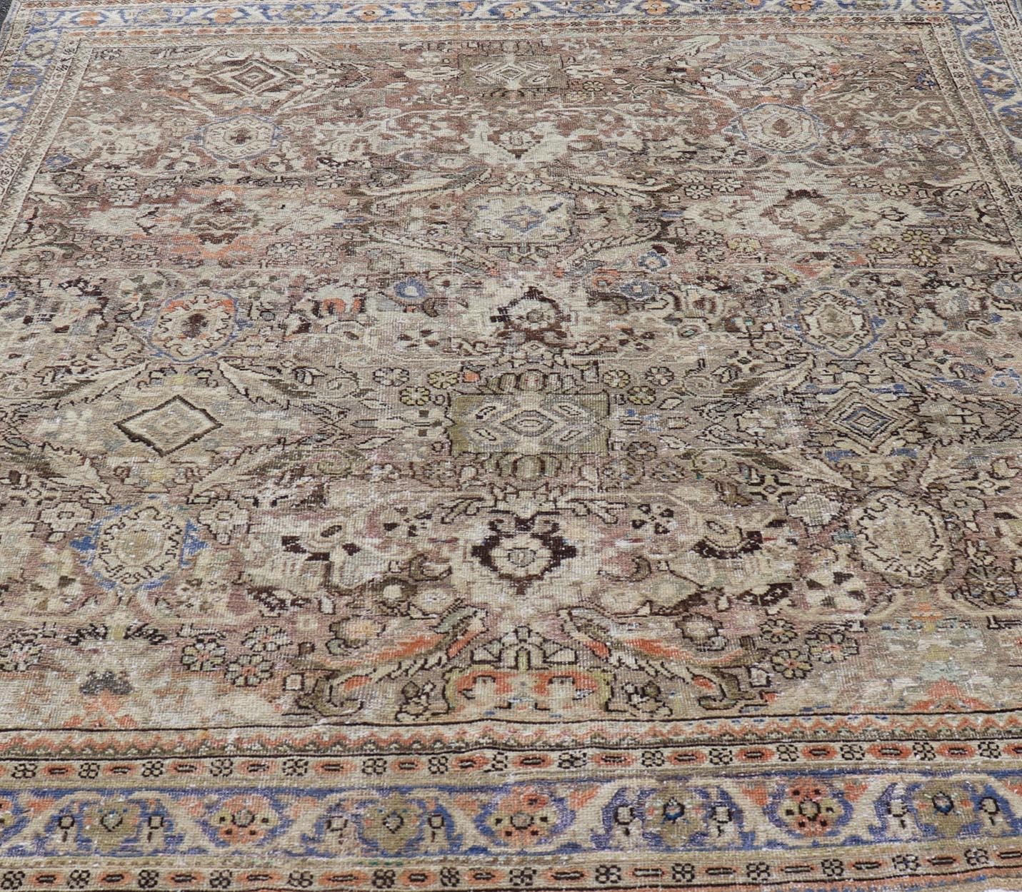 This distressed antique Persian Mahal displays geometric flowers and an all over design in earth tones. 
Keivan Woven Arts Rug/PTA-200724, country of origin / type: Persian / Sultanabad-Mahal, circa Early-20th Century. This rug blue border with lots