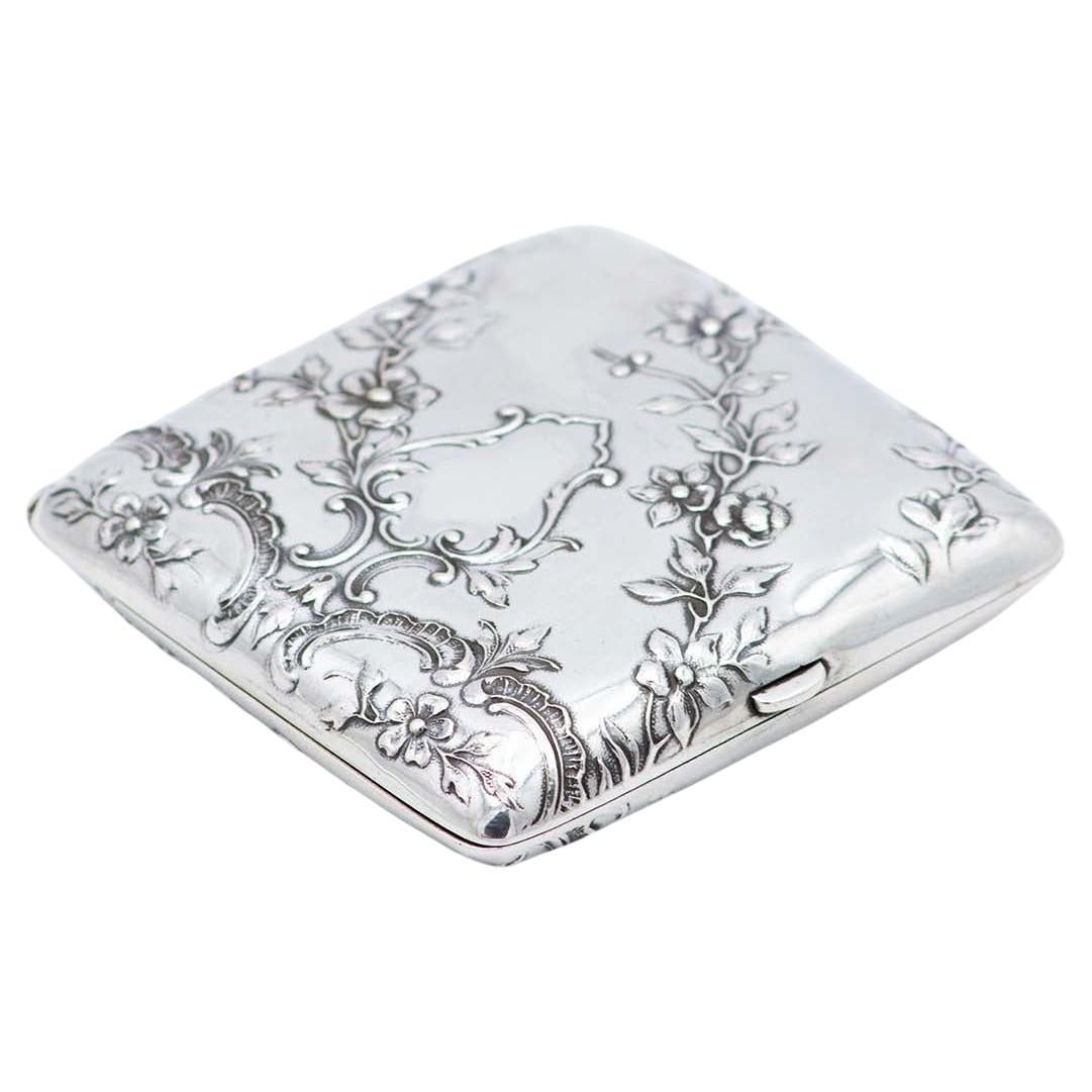 Square Art Nouveau silver case with embossed florals and gold interior
