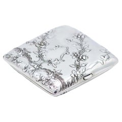 Square Art Nouveau silver case with embossed florals and gold interior