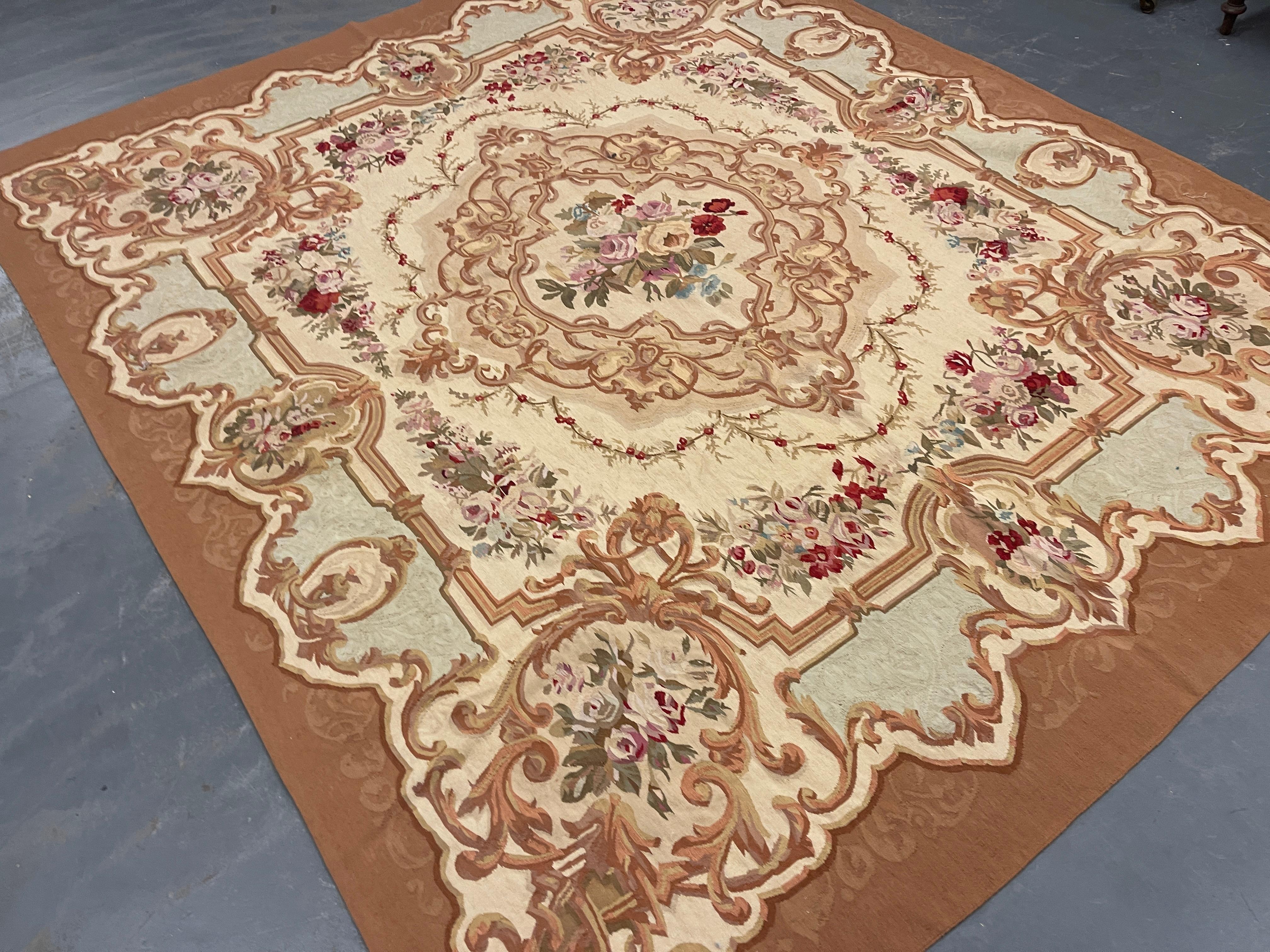Esta fantástica alfombra cuadrada ha sido tejida a mano con un precioso diseño floral simétrico sobre un fondo marrón-azul con detalles en crema, verde y marfil. El color y el diseño de esta elegante pieza la convierten en la alfombra de acento
