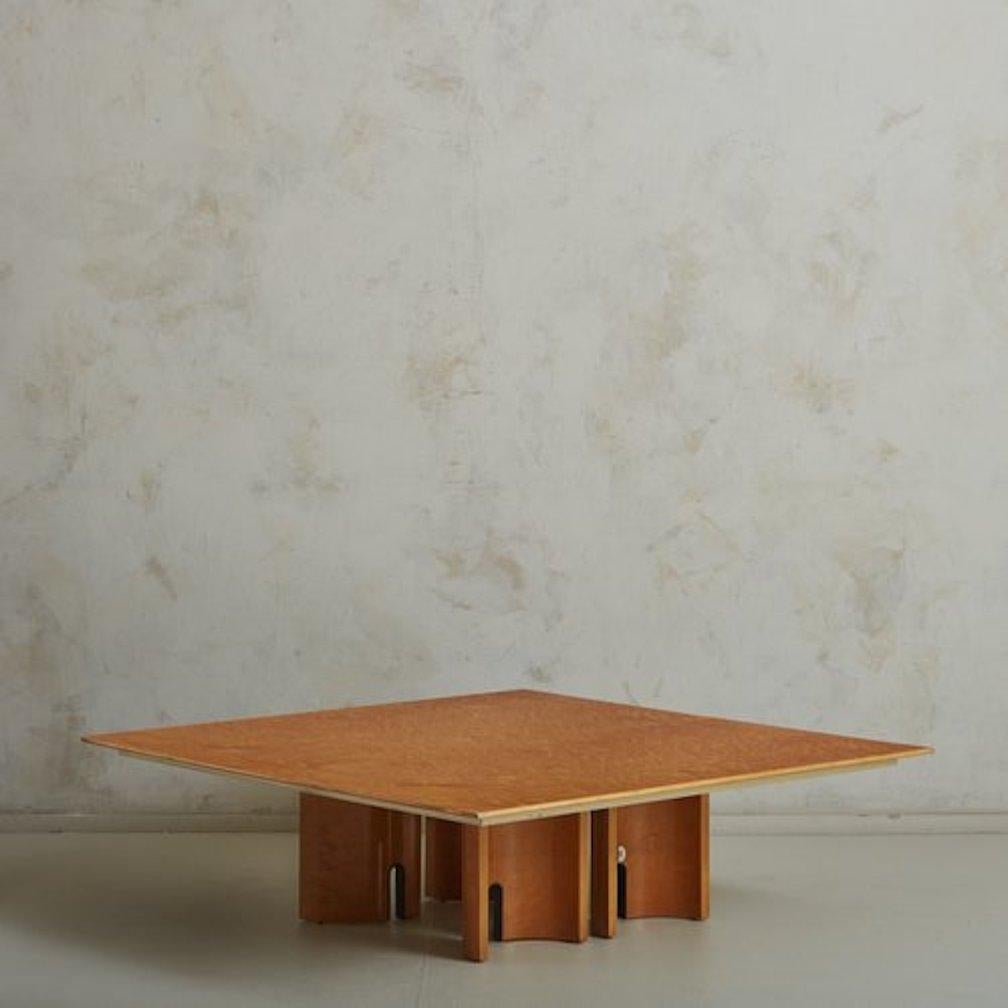 A gorgeous square coffee table designed by Giovanni Offredi for Saporiti in the 1980s. This table was constructed with wood and has a striking birdseye maple veneer. The base consists of four demilune supports featuring sculptural arch cutout