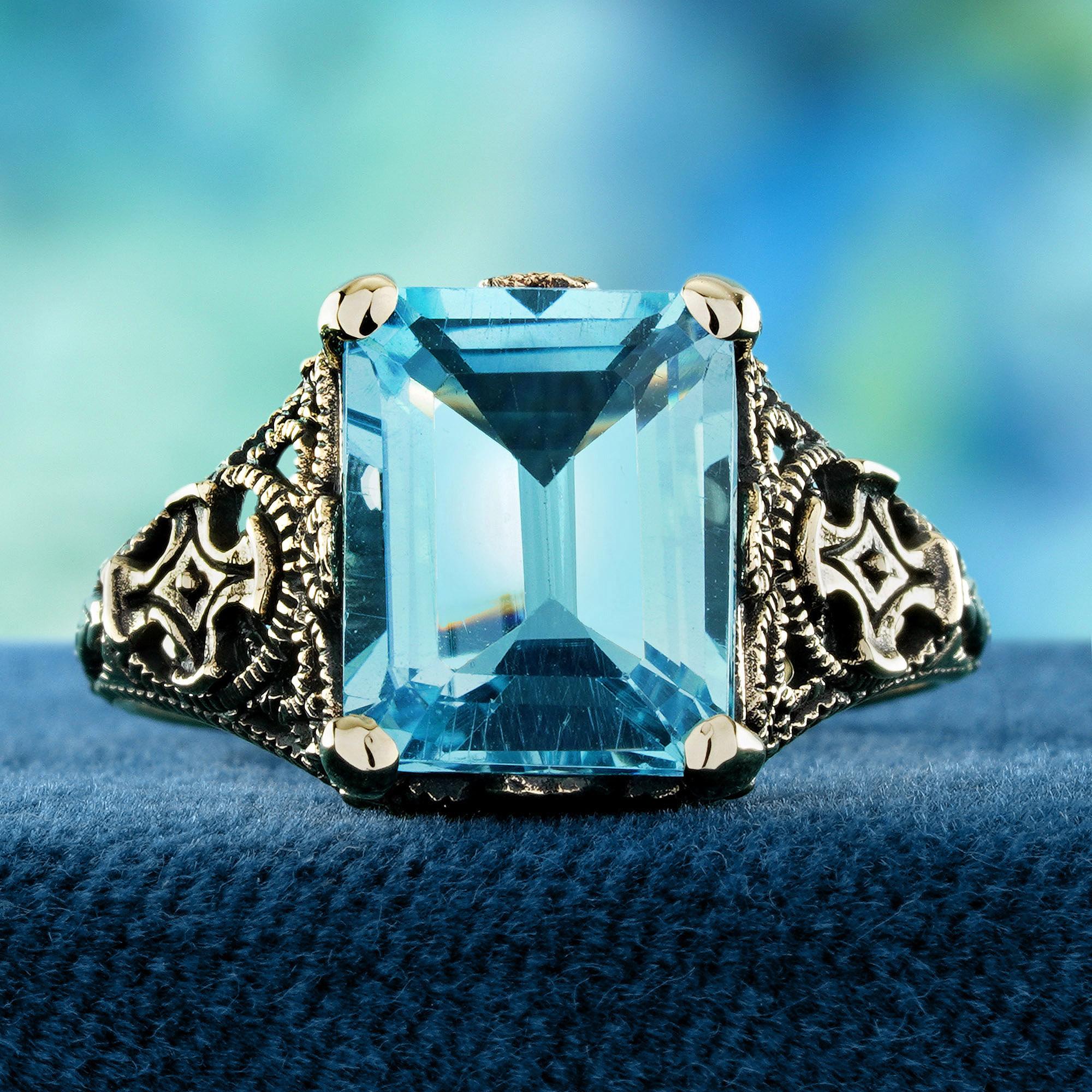This vintage-style ring features a natural square-cut Blue Topaz in a secure prong setting.Its vivid blue color offers a brilliant, eye-catching sparkle. Delicate floral filigree along the band adds antique-inspired elegance. Expertly crafted to