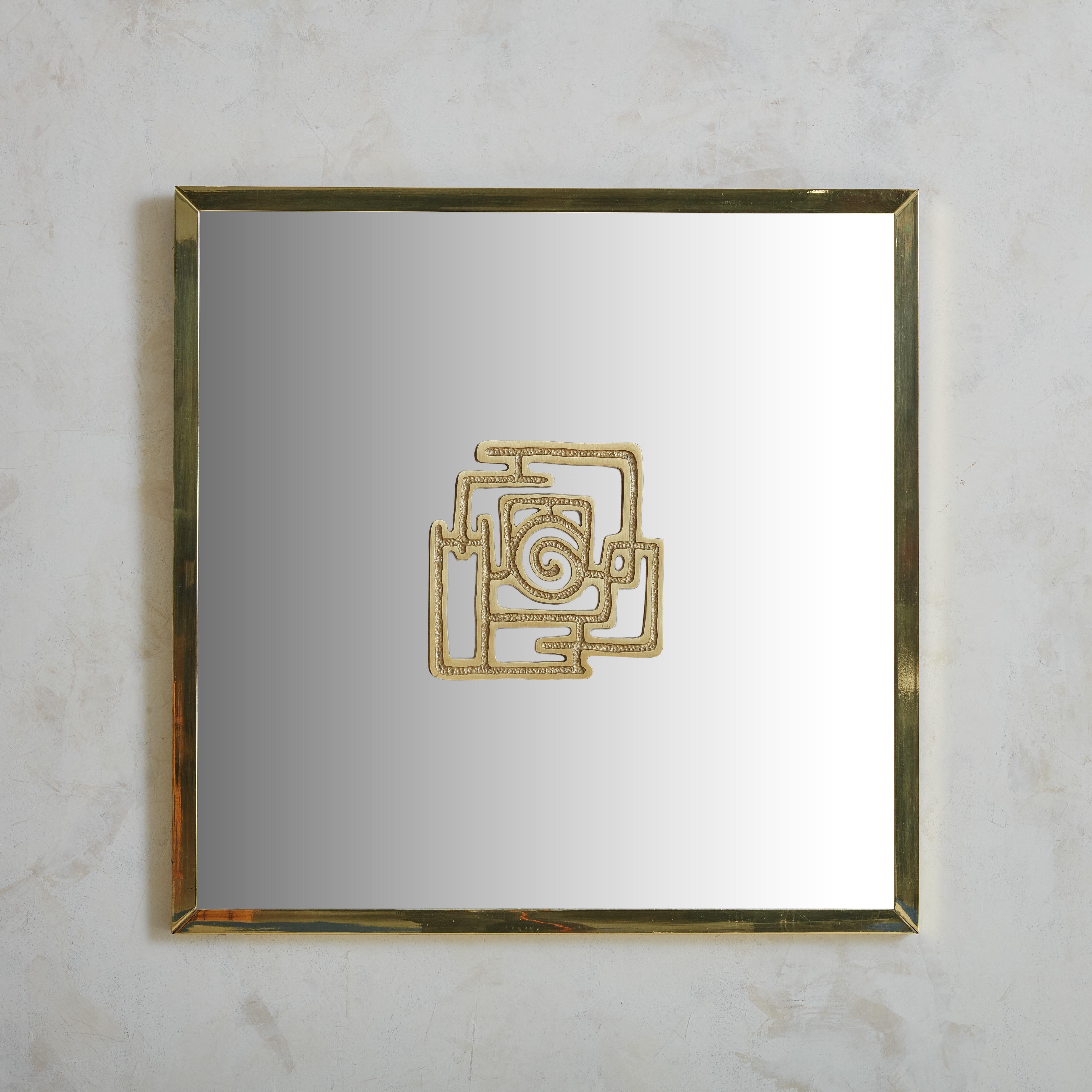 Beautiful bronze framed mirror with hand forged central medallion, attributed to Luciano Frigerio. This stunning piece features a perfect contrapposition between industrial production, in the frame, and Italian craftmanship in the hammered bronze