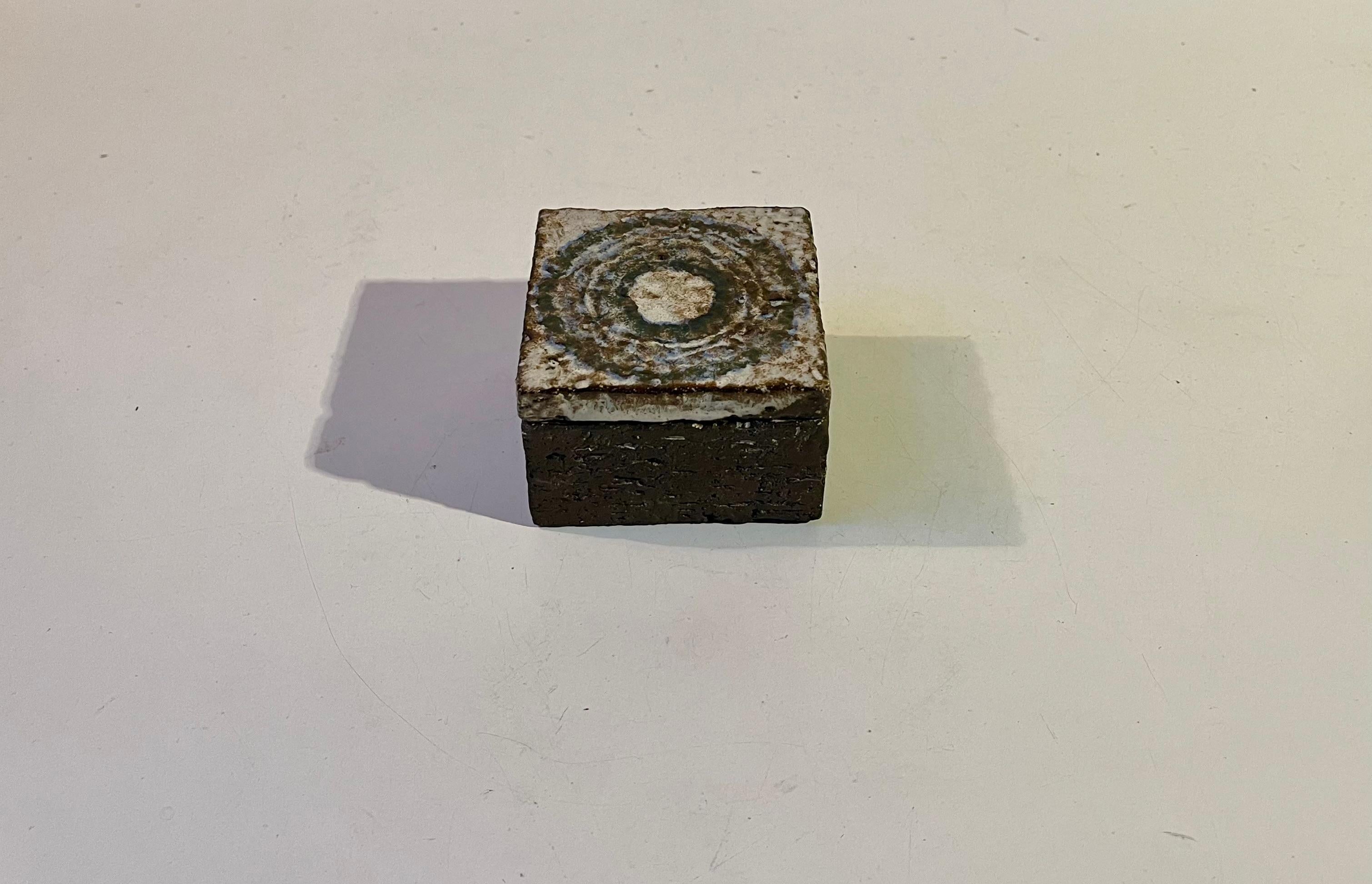 Roh aussehender, aber fein glasierter quardratischer Schmuckkasten aus glasiertem Steinzeug. Abstraktes kreisförmiges Deckelmotiv in erdigen/staubigen Glasuren. Brilliantes Dekorationsstück für persönliche Kleinigkeiten, Schmuck oder materialisierte