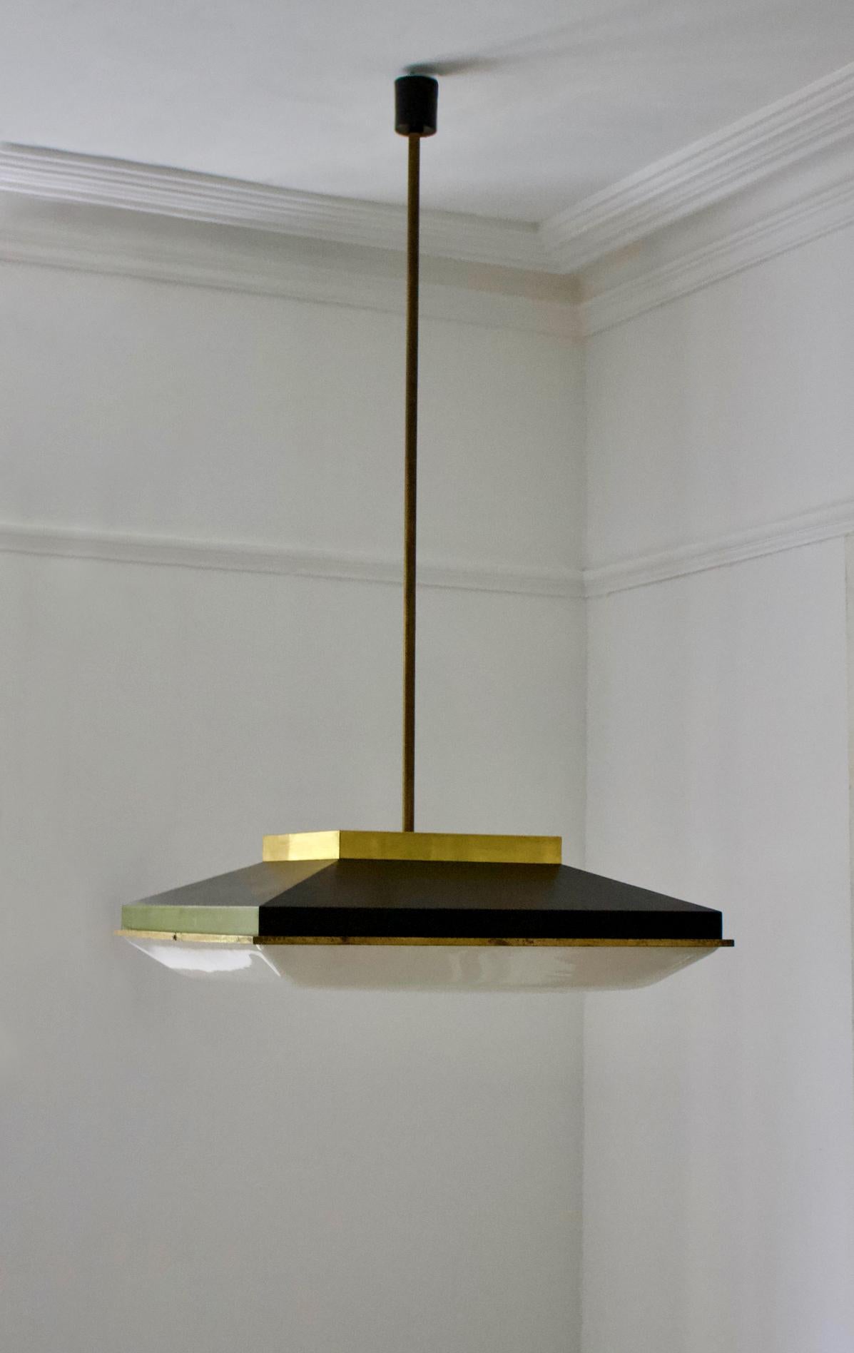 A striking square pendant light with black lacquered frame, plexiglass diffuser, and brass details. Design attributed to Stilnovo of Italy, 1960s.

Good condition, with minor signs of age-related wear and aged patina to the brass. The scale of this