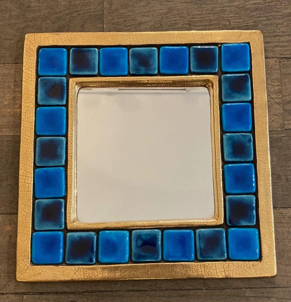 Square ceramic wall mirror.
Enameled blue tiles in a gilded frame 
 Enameled ceramic
Original green felt at the back, with ware in the corners 
Mithé Espelt (born 1923)
Lunel, south of France,
circa 1970
This poetic work of art demonstrates