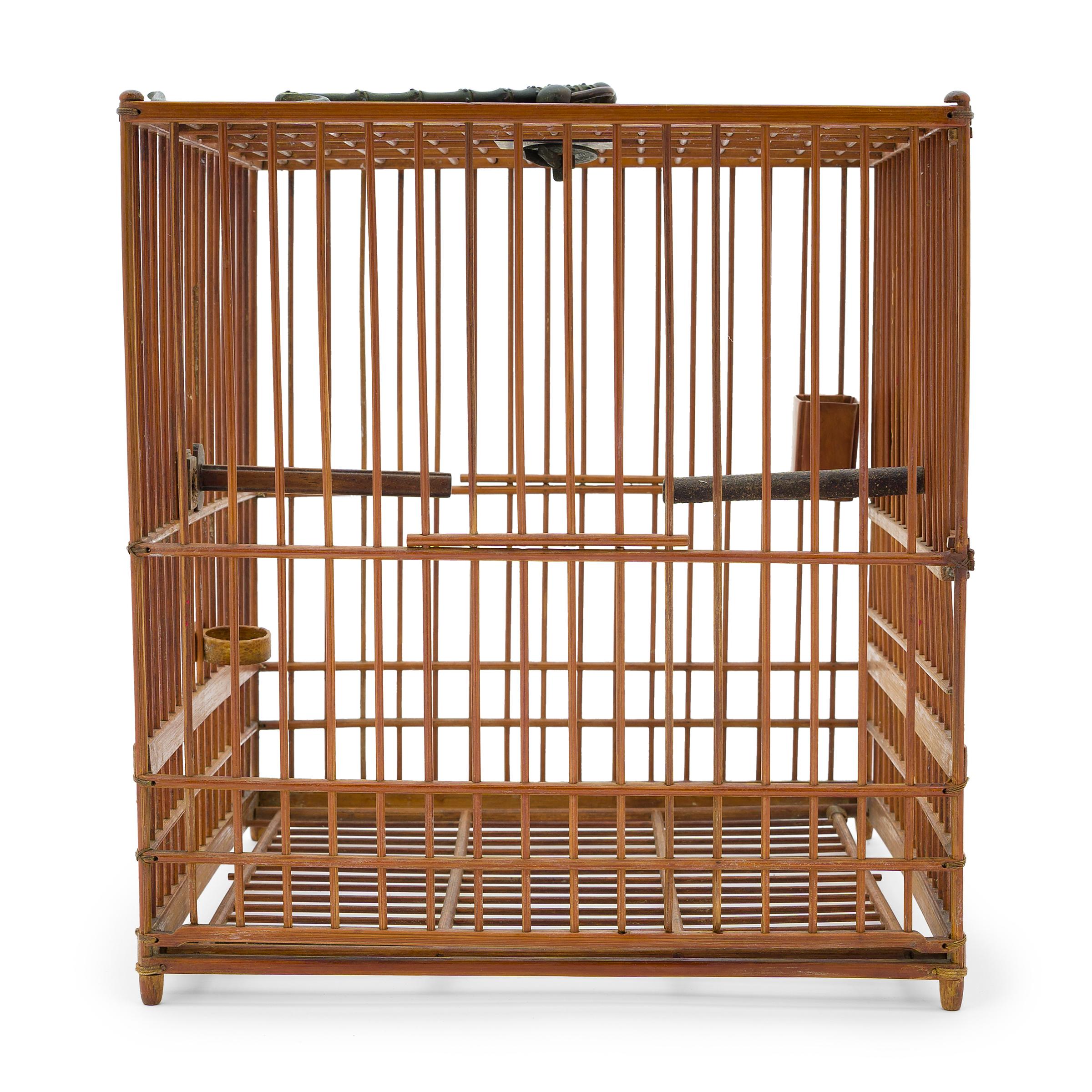 Cette cage à oiseaux bien proportionnée abritait autrefois l'animal de compagnie d'un aristocrate de la dynastie Qing. Datant du début du 20e siècle, cette cage carrée est soigneusement assemblée à partir de fines tiges de bambou. Elle est dotée