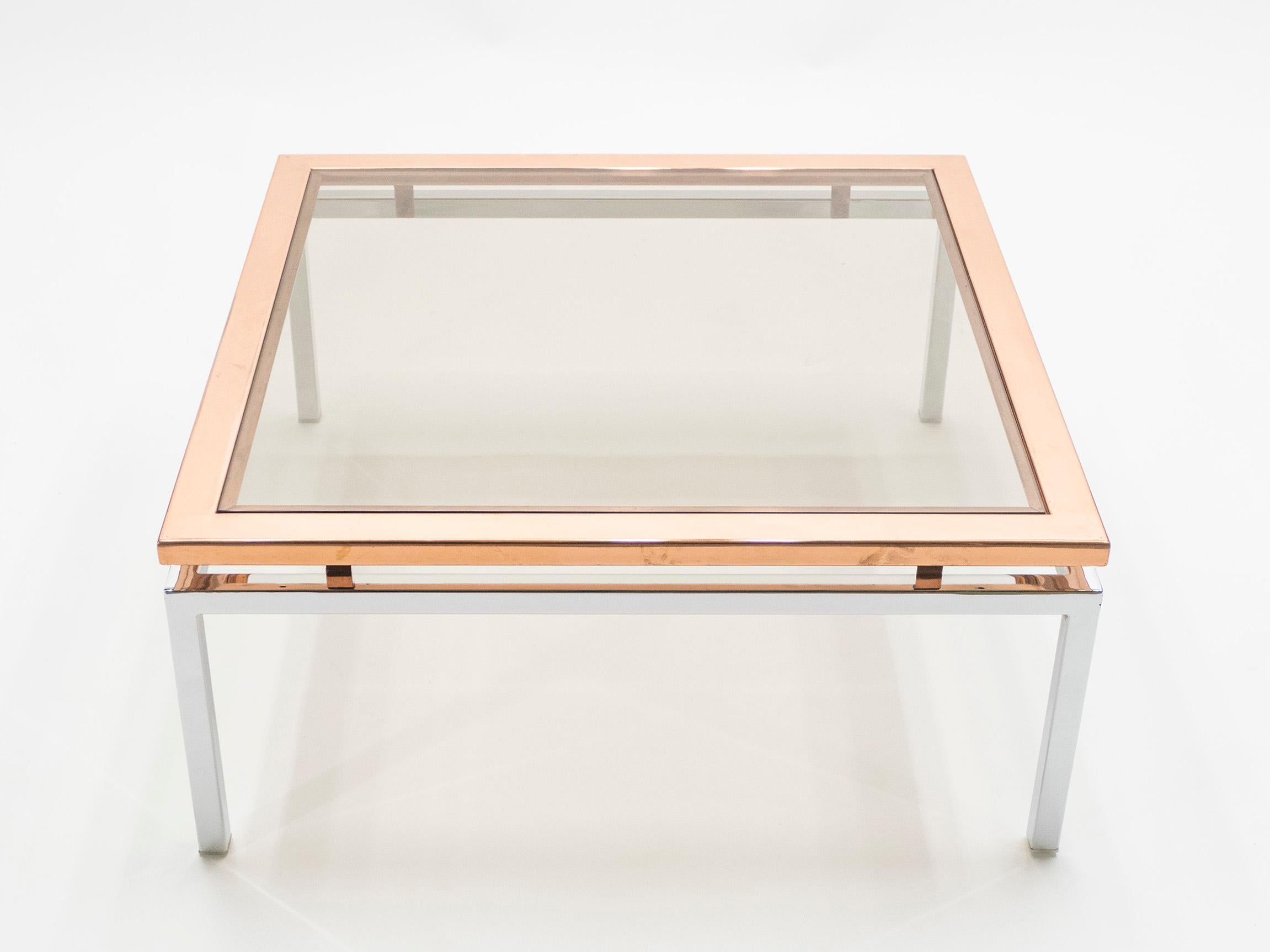 Simple lines and shiny metal point to this coffee table midcentury roots. Designed by Guy Lefevre for Maison Jansen, it features chrome legs and with a large copper frame top covered by a lightly smoked glass. Its symmetry, elevated glass, and