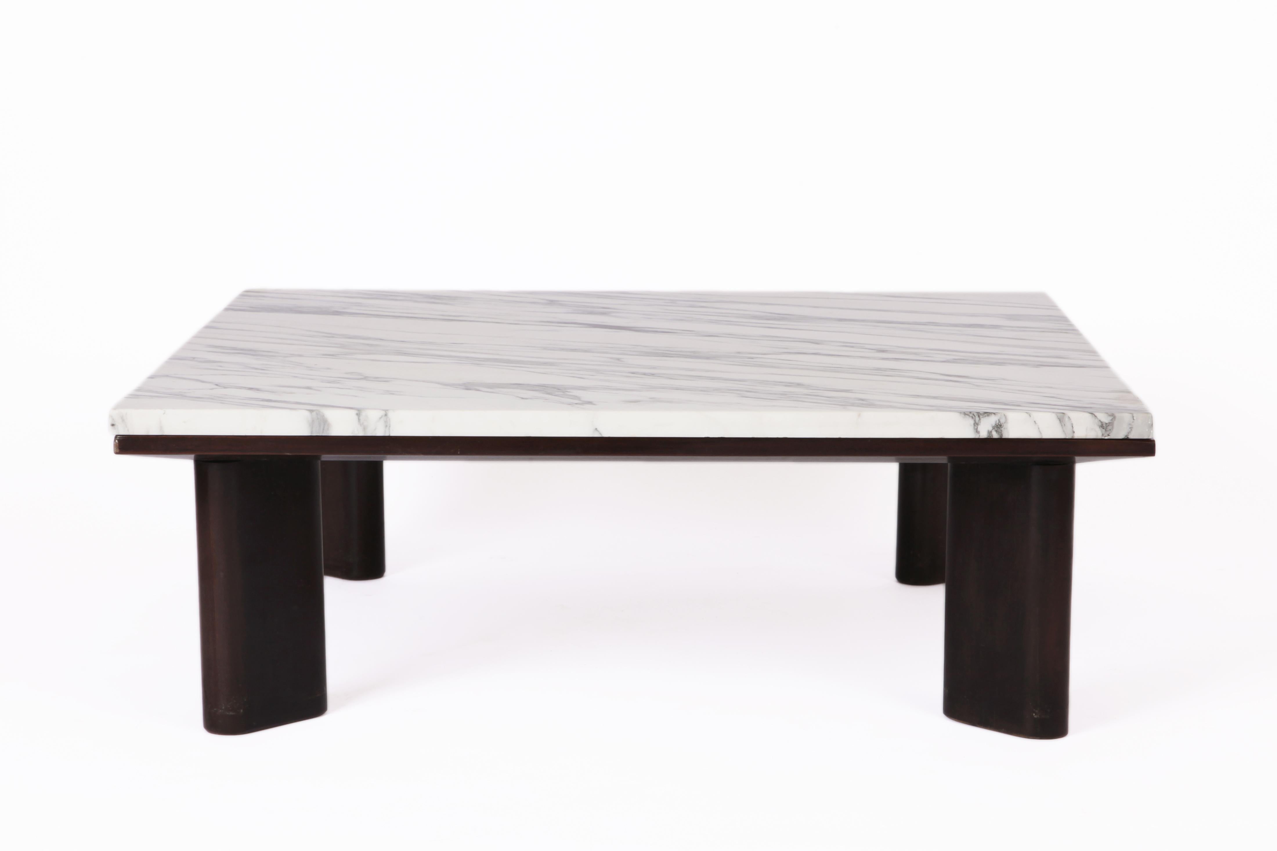 A marble and wood coffee table by Joaquim Tenreiro. 1960

The modern legs in the shape of an ellipse, a flush construction of the marble top with the wooden structure.  
A contrast between the two materials; the thickness of marble is identical to