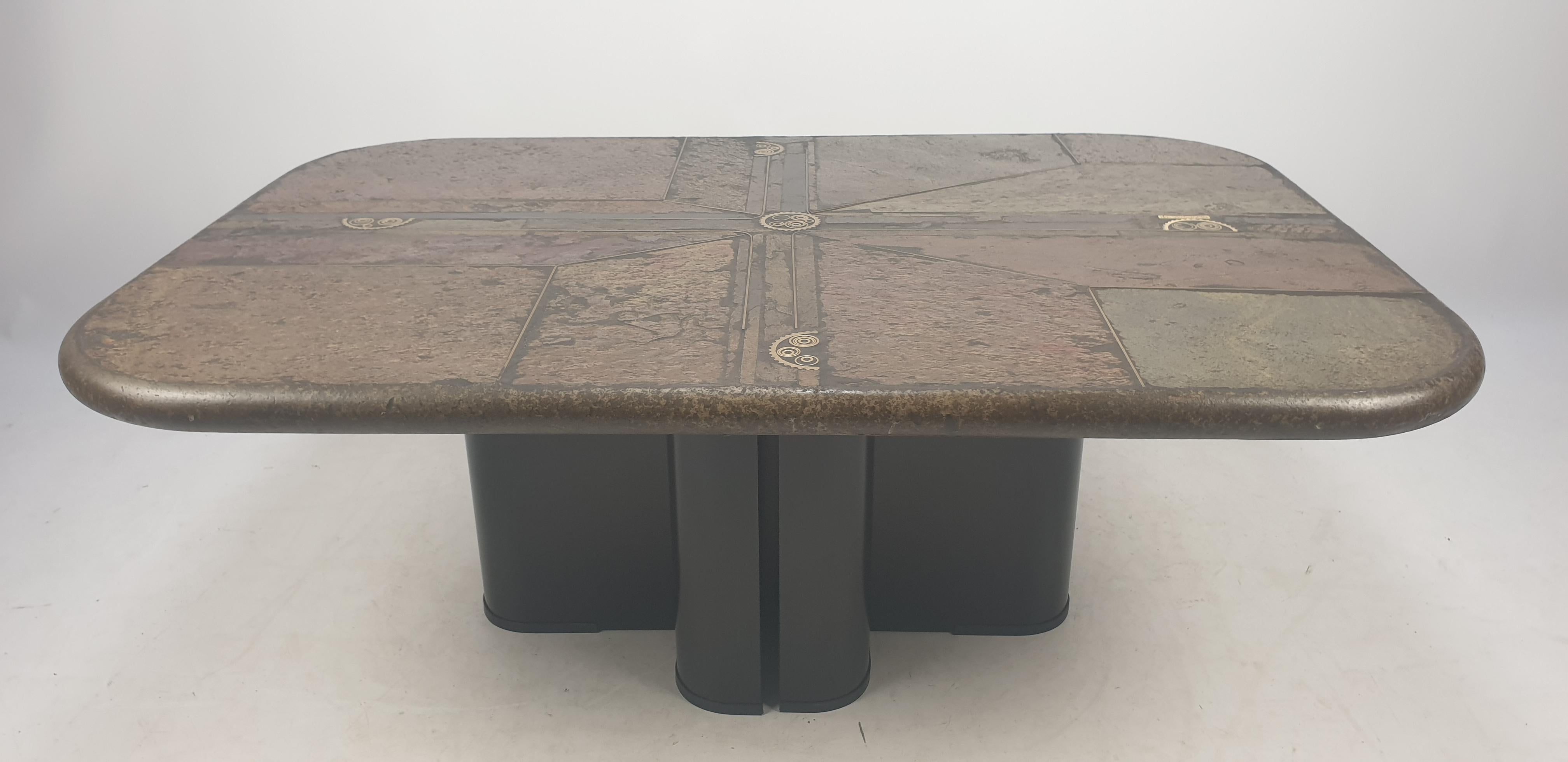 This eye-catching coffee table was designed and marked by M. Kingma '91. This very nice table has a concrete blade inlaid with a mosaic of stone (in different colors and textures) and brass. The base can be used in various positions and is made of