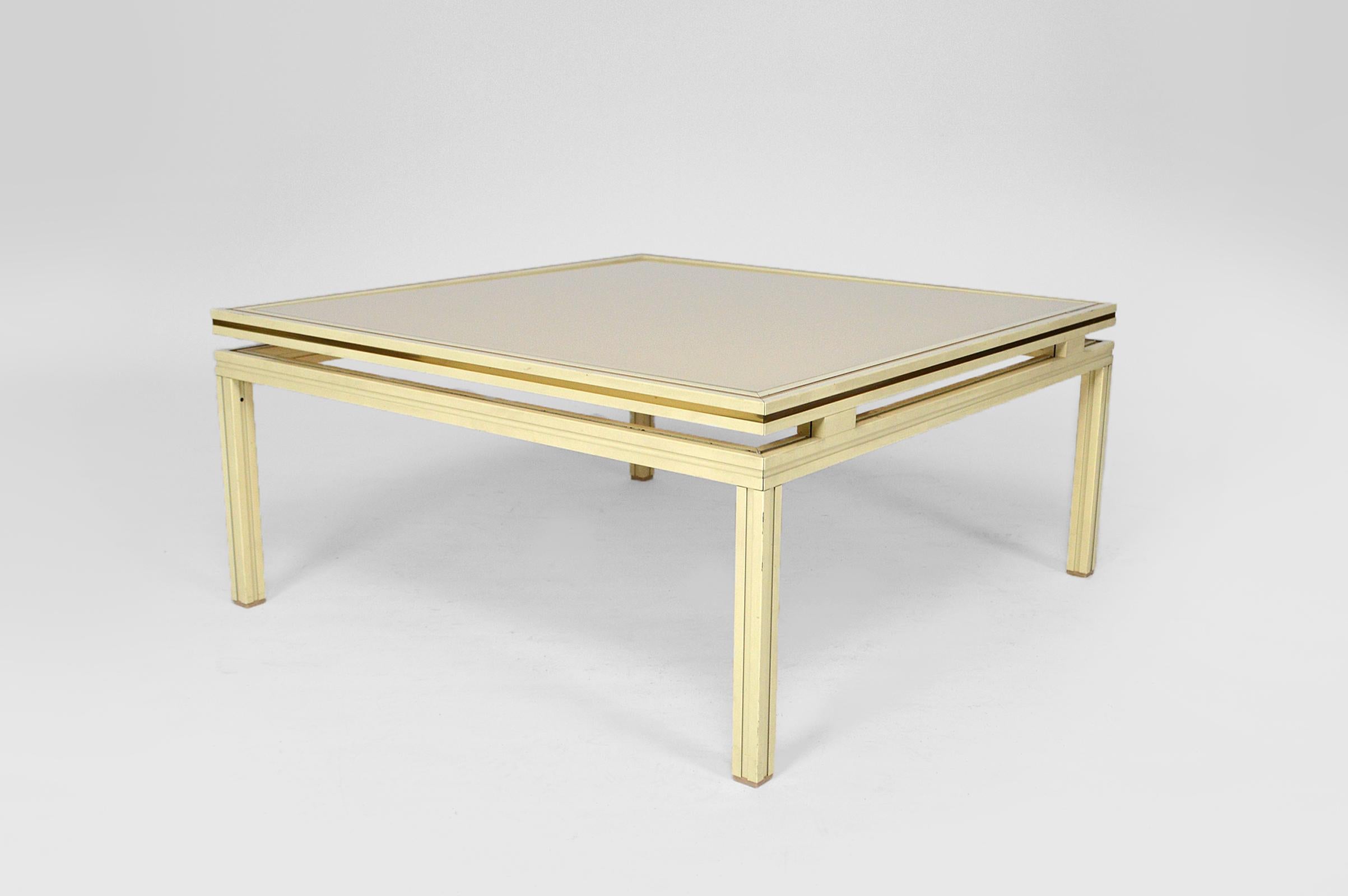 Square coffee / side table in white lacquered aluminium enhanced with brass fillets, and with glass top.

In good condition.
Mid-Century Modern, France, 1970s.
By Pierre Vandel.
Manufacturer's plate presents: 