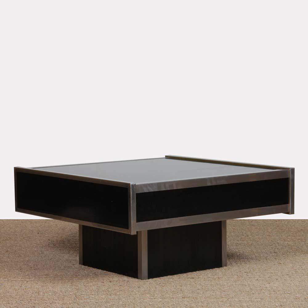 This square coffee table is in the tasteful style of designer Willy Rizzo. It dates from the 1970s. This piece of furniture is made of glass with a metal frame. This piece of furniture is in good vintage condition.