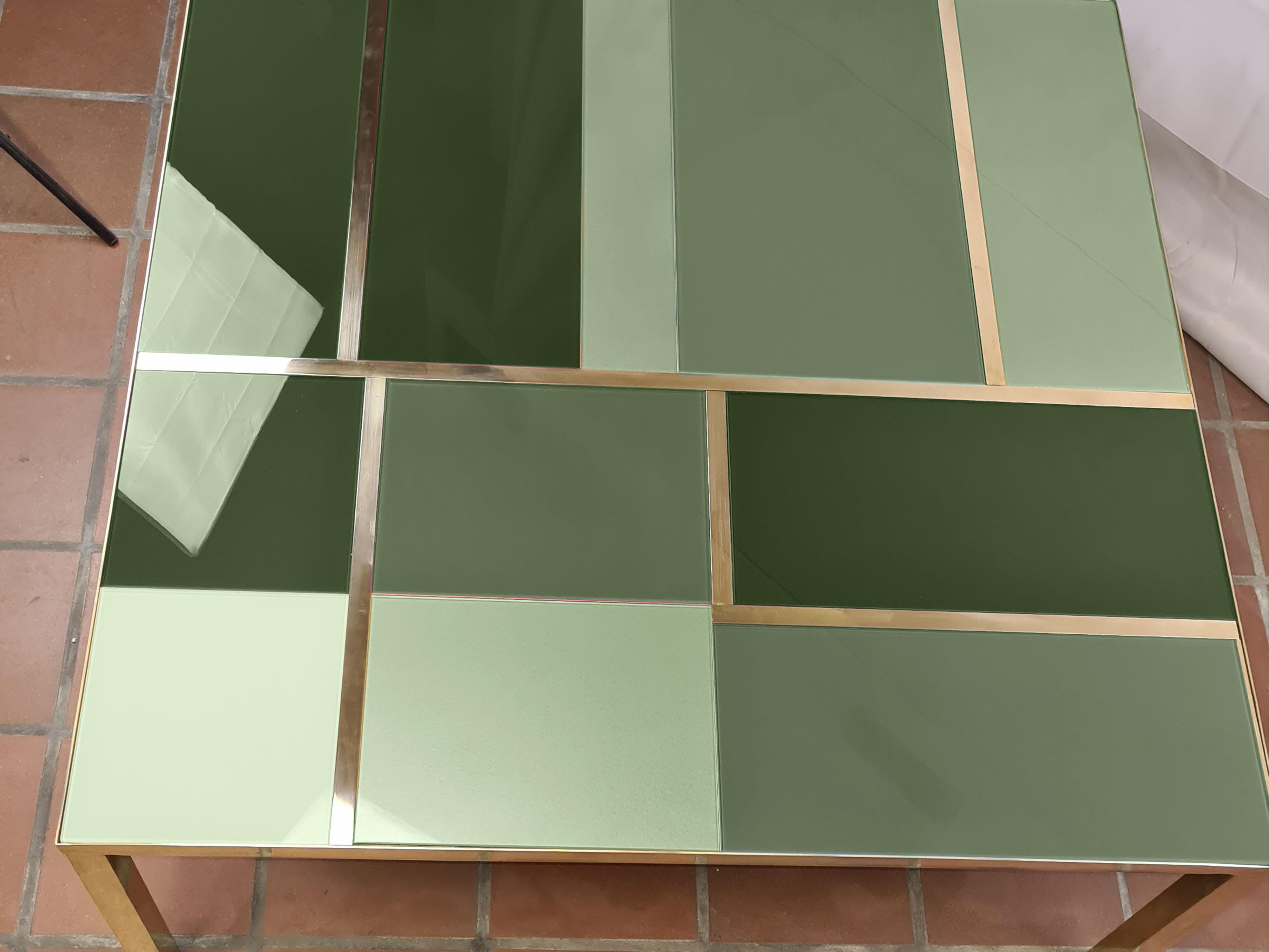 This square coffee table features green Murano glass of different shades and elegant brass bands, embodying the Mid-Century Modern style. 

Handcrafted in Italy, this coffee table combines artistic design and functionality. The Murano glass top, is