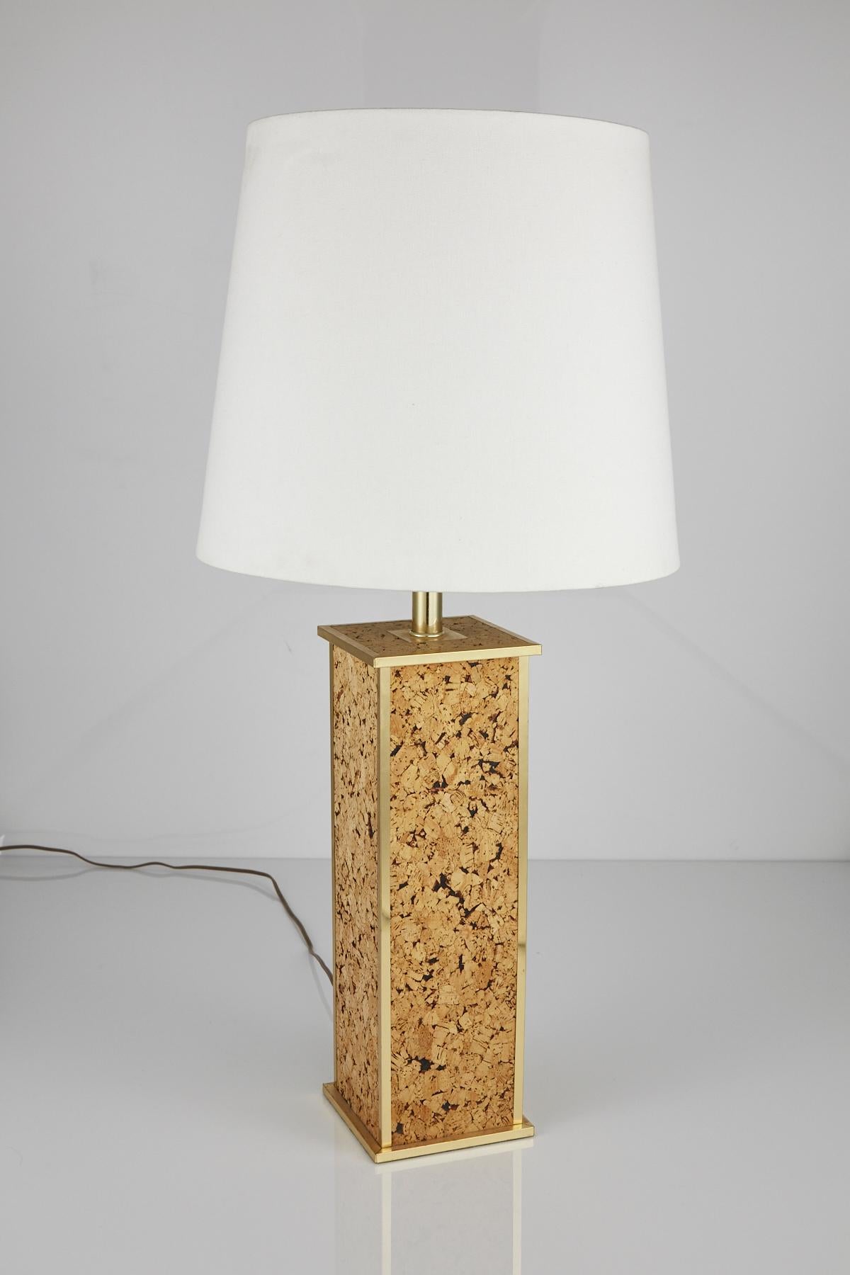 Square columnar base wrapped in cork, accented with brass trim and neck. American made, from the 1970s.

Does not come with shade or harp seen in images. Body of lamp only.