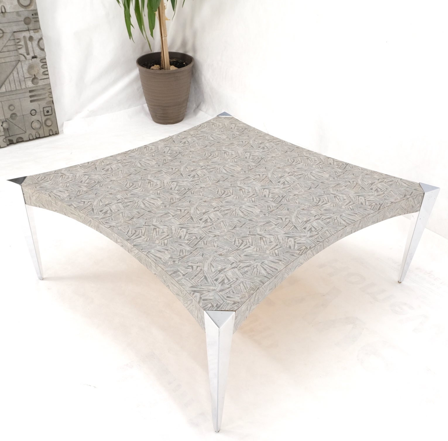 Côtés concaves carrés, pieds triangulaires effilés en aluminium, table basse avec plateau en paternité.