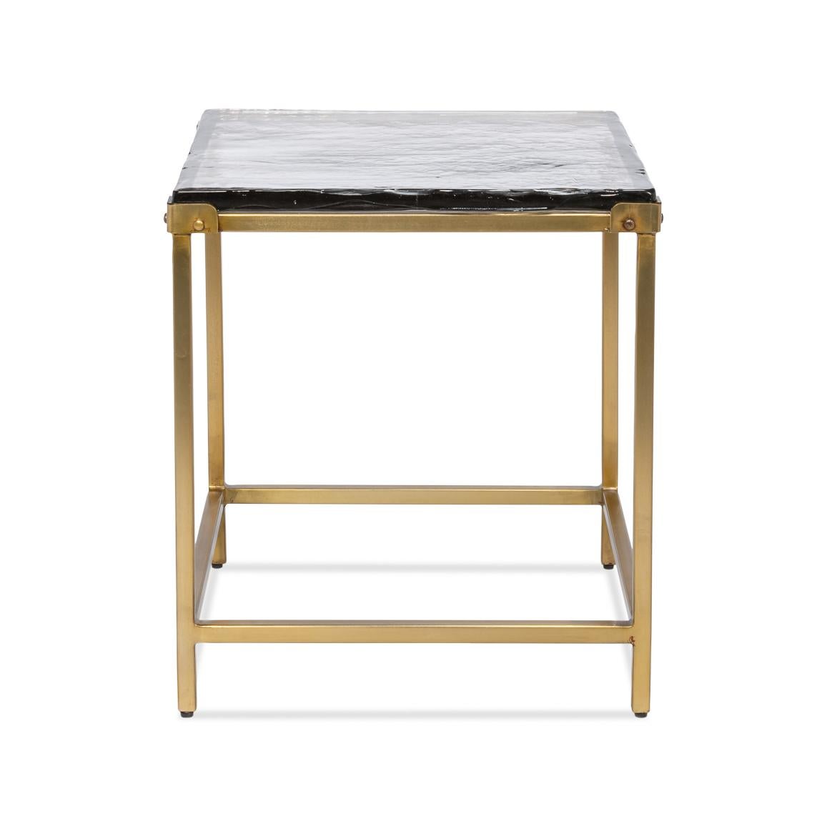 Cette pièce exquise présente une base en fer forgé à la main avec une finition en laiton doré vieilli, apportant une touche d'élégance vintage tout en conservant une esthétique contemporaine épurée. Le plateau en verre moulé, avec sa texture