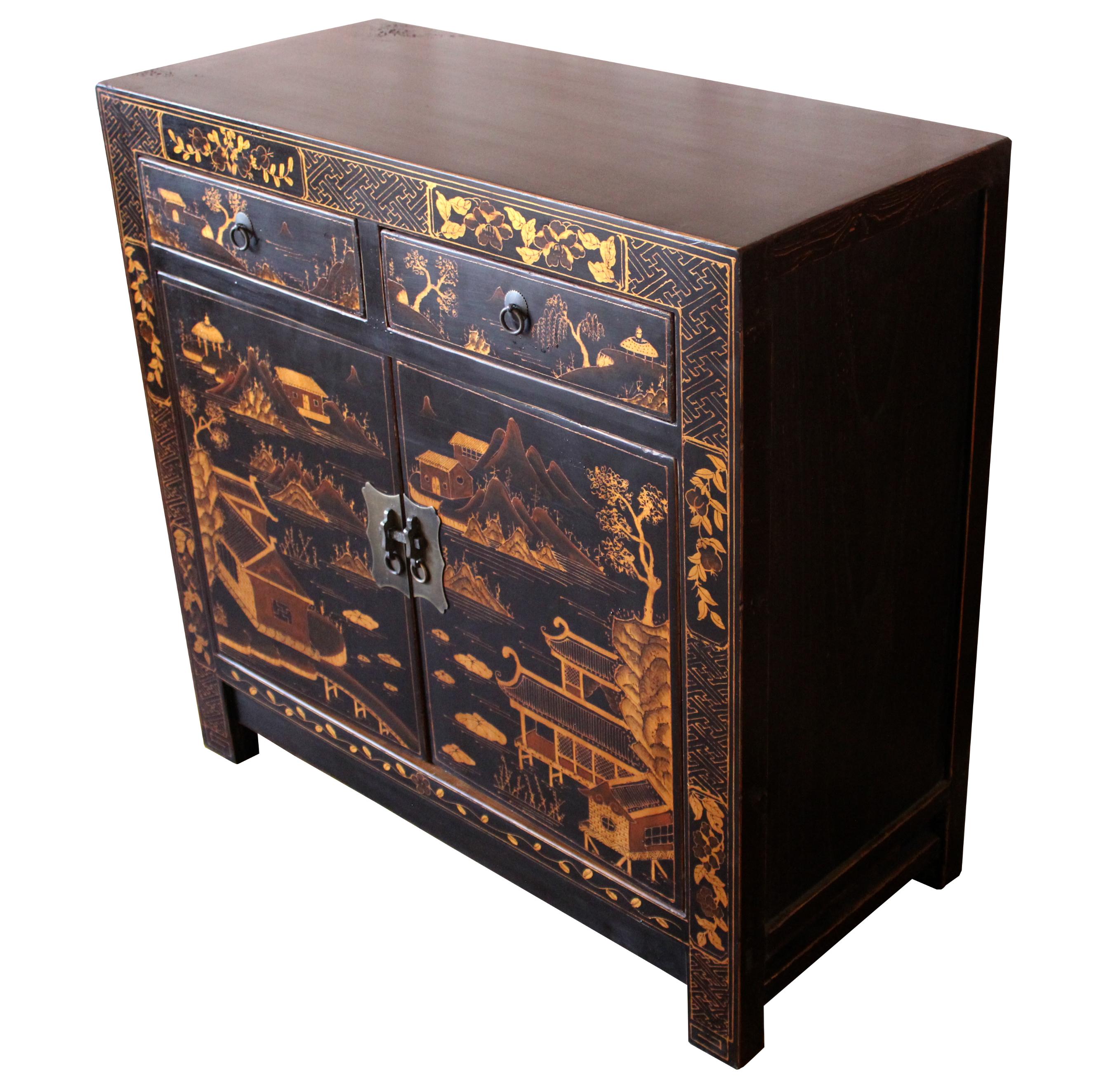 This vintage gilt painted cabinet on black lacquer will be an exquisite showpiece in a traditional living room or dining room. The elaborately painted houses surrounded by lake, small hills, and trees adorns two-door panels and two-drawer fronts.
