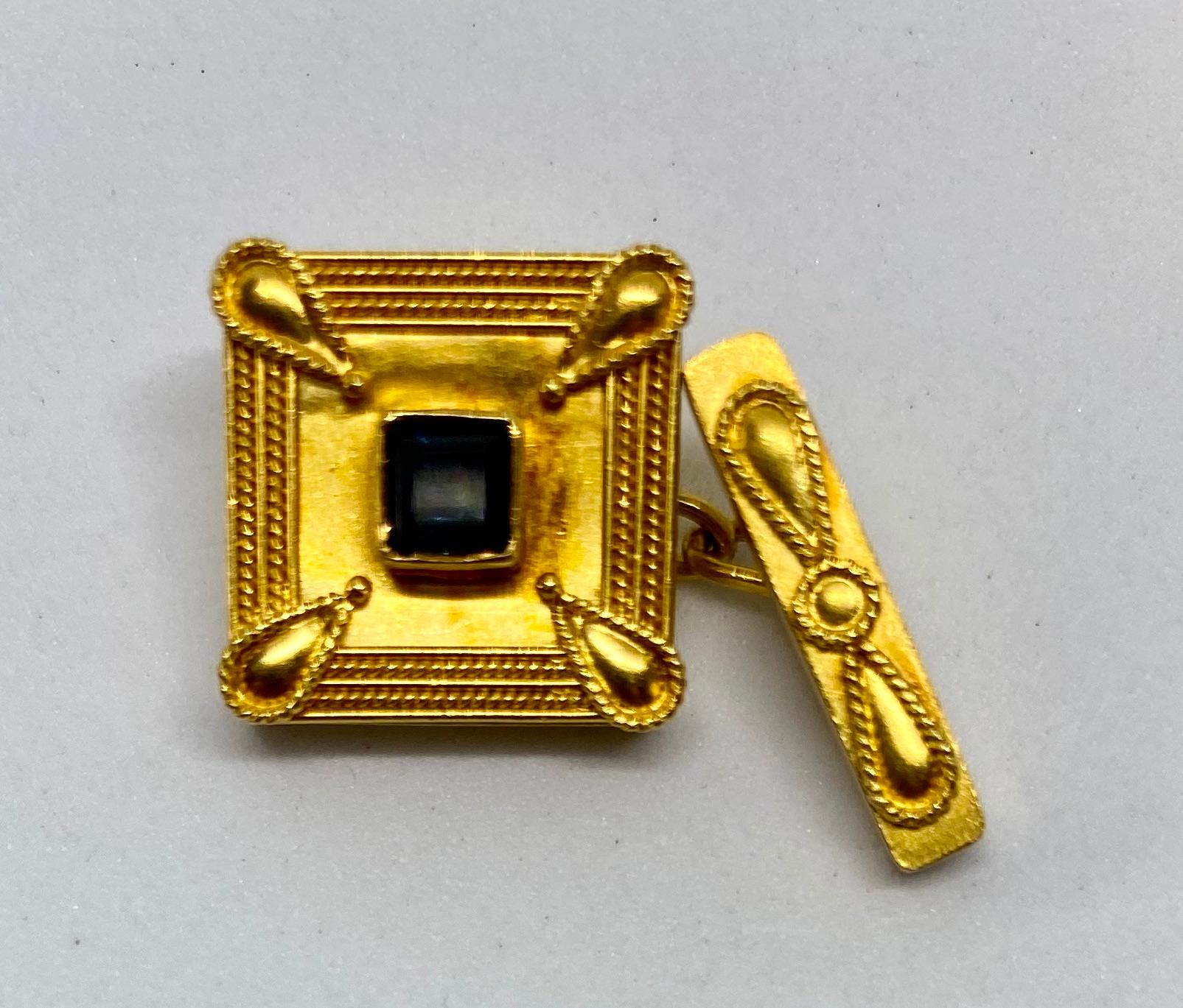 Beautiful cufflinks displaying an extremely high level of the goldsmith's art. With square-cut blue sapphires at their centers, each cufflink face is bordered by two rows of perfectly hand-rendered gold rope. The faces are backed with rectangular