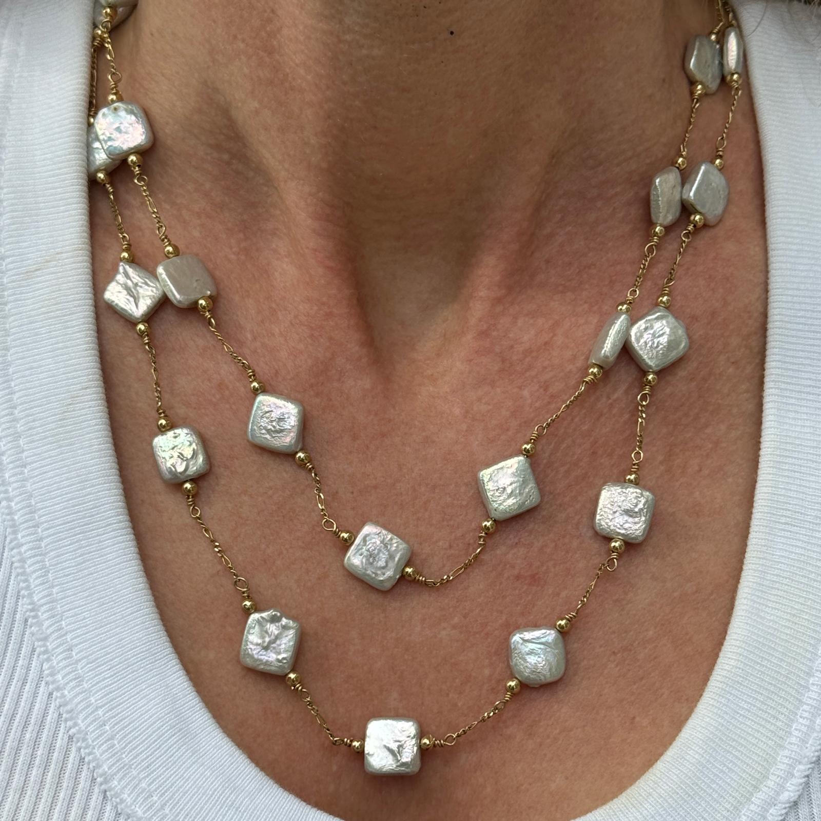 Feminine, zweireihige Perlenkette aus 14 Karat Gelbgold. Die Halskette besteht aus quadratischen Zuchtperlen, die in Abständen an einer zweireihigen Kette angebracht sind. Die Halskette misst 17 Zoll (kürzerer Strang) und 19 Zoll. Gewicht: 26 Gramm.