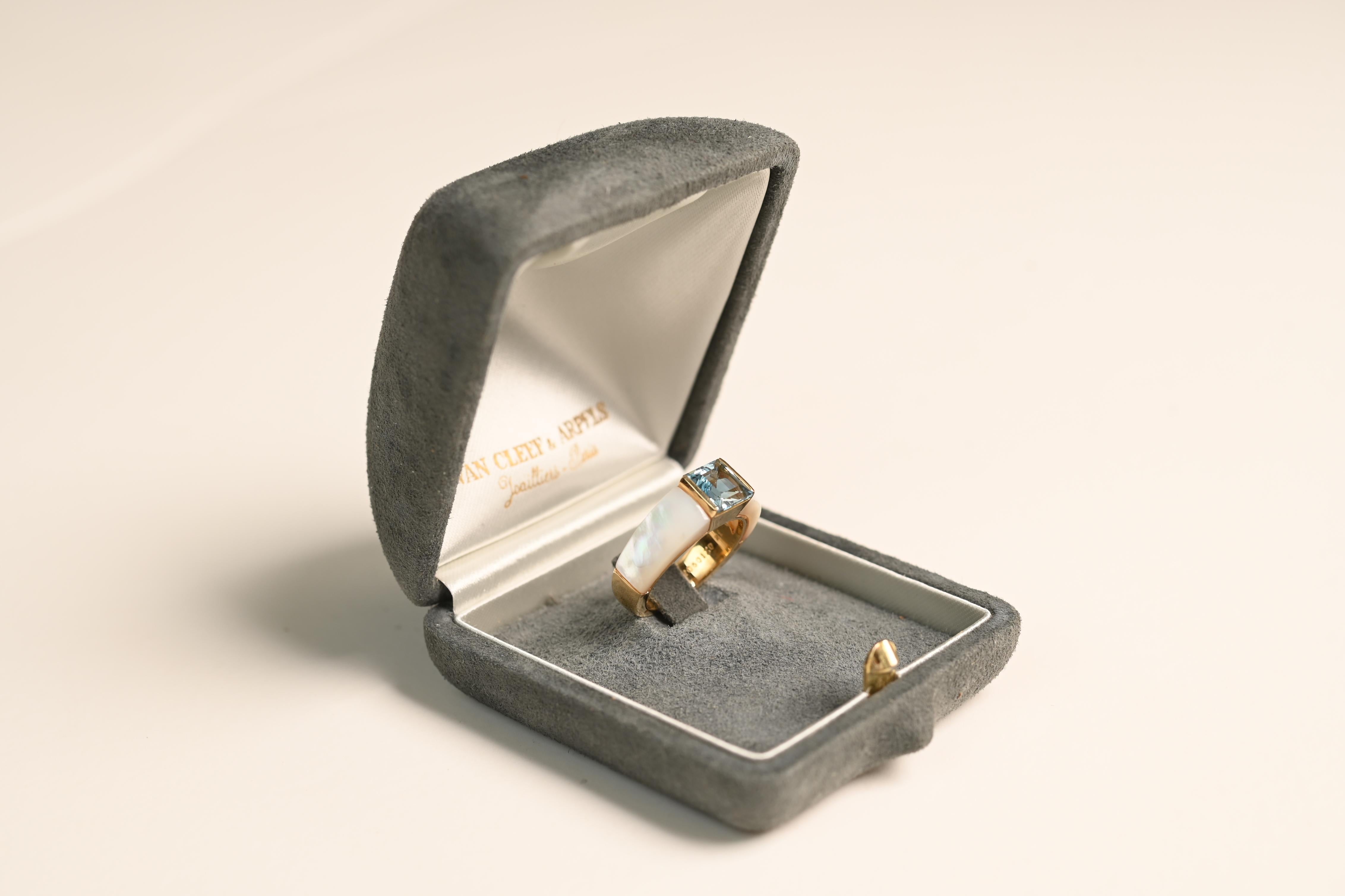 A stunning Van Cleef & Arpels ring featuring a mesmerizing square-cut aquamarine center stone, weighing approximately 1.50-carats. The aquamarine is bezel-set in rich 18k yellow gold, enhancing its crisp, cool blue hue with a warm and elegant