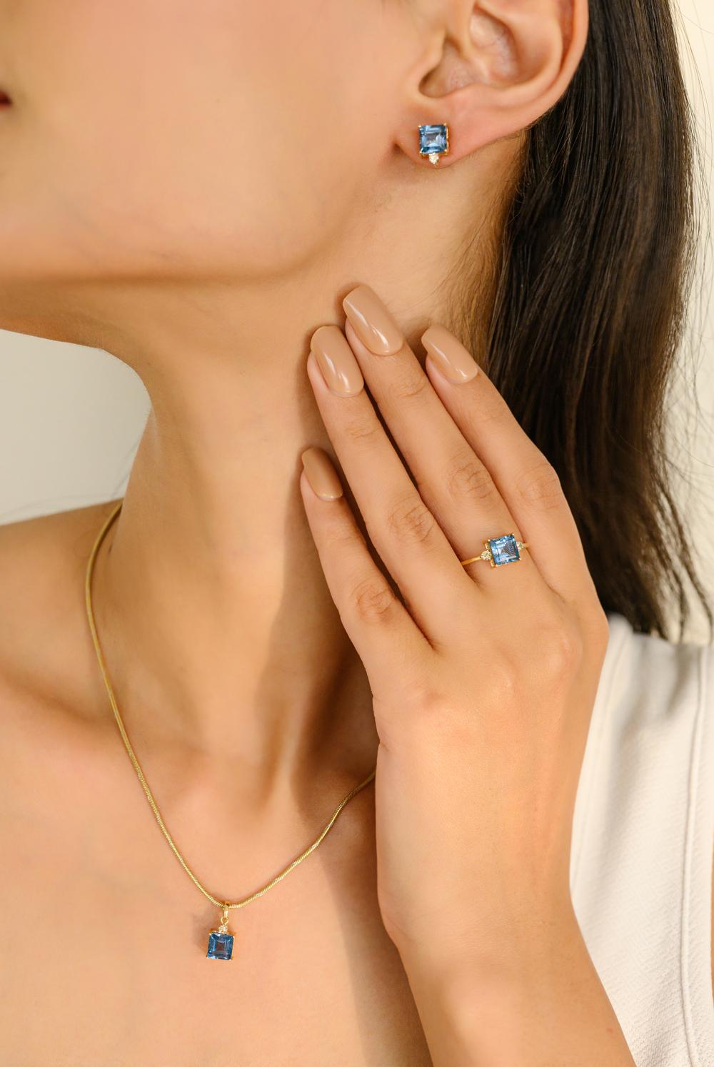 Bague pendentif diamant Topaze bleue taille carrée Boucles d'oreilles en or 18 carats serties de topaze bleue taille carrée et de diamants ronds. Ce superbe bijou rehausse instantanément un look décontracté ou une tenue habillée. 
La topaze bleue