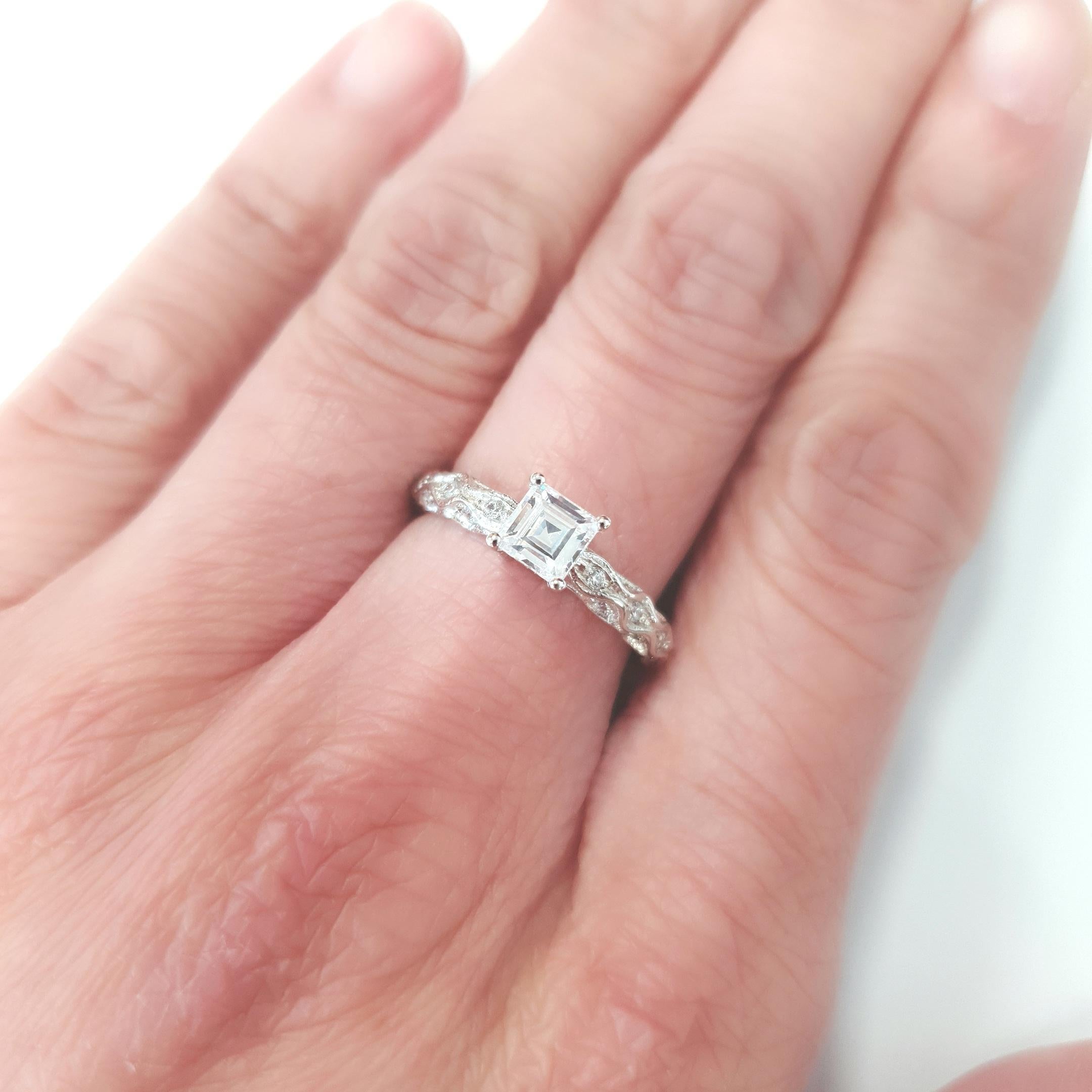 Introducing the epitome of elegance and romance, behold the Spring Willow 0.25ct Engagement Ring. This exquisite piece showcases a sterling silver band adorned with sparkles of cubic zirconia intricately woven into the the shoulders of the ring. At