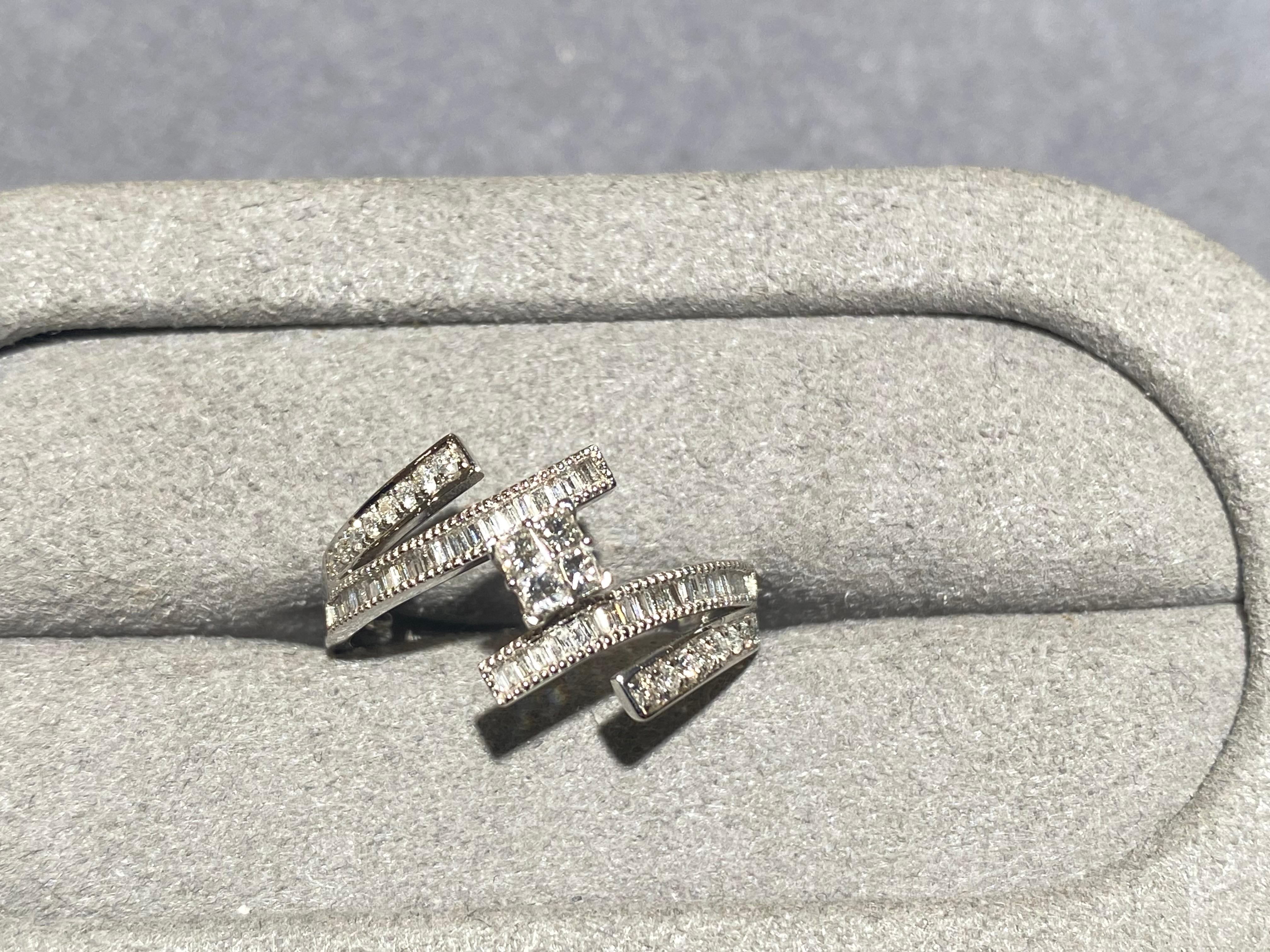 Square diamond ring in 18k white gold. There are 4 small square diamonds set in the middle of the ring. The diamonds are connected to 2 ribbon-like structure, encrusted in micro diamond pave. This is a simple design and is perfect for everyday