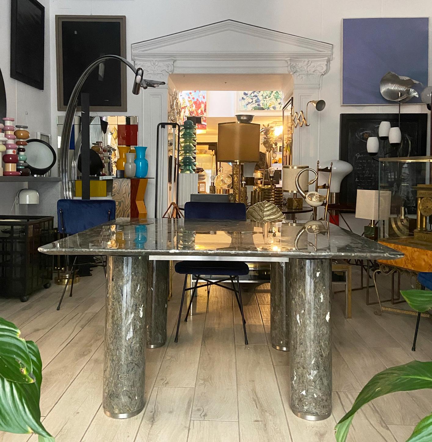 This beautiful dining table was designed in Italy in the 1970s. It is composed of a labradonite marble top resting on four cylindrical columns in solid marble.