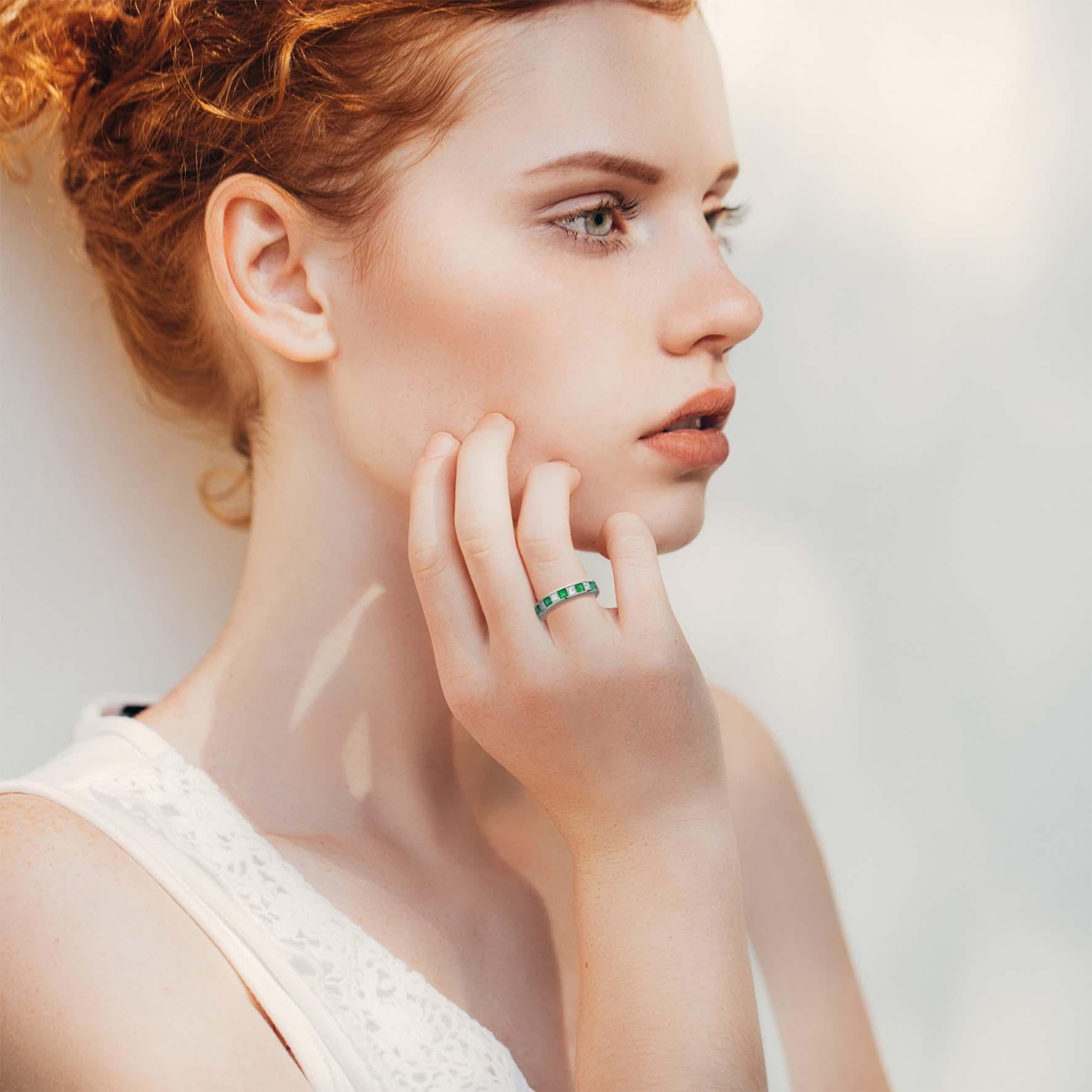 Fabulous square emeralds and dazzling diamonds alternatively adorn this channel set half eternity band. The green emeralds and white diamonds exude a stunning contrast and are set in platinum 950. A truly stunning unisex ring design that can be worn
