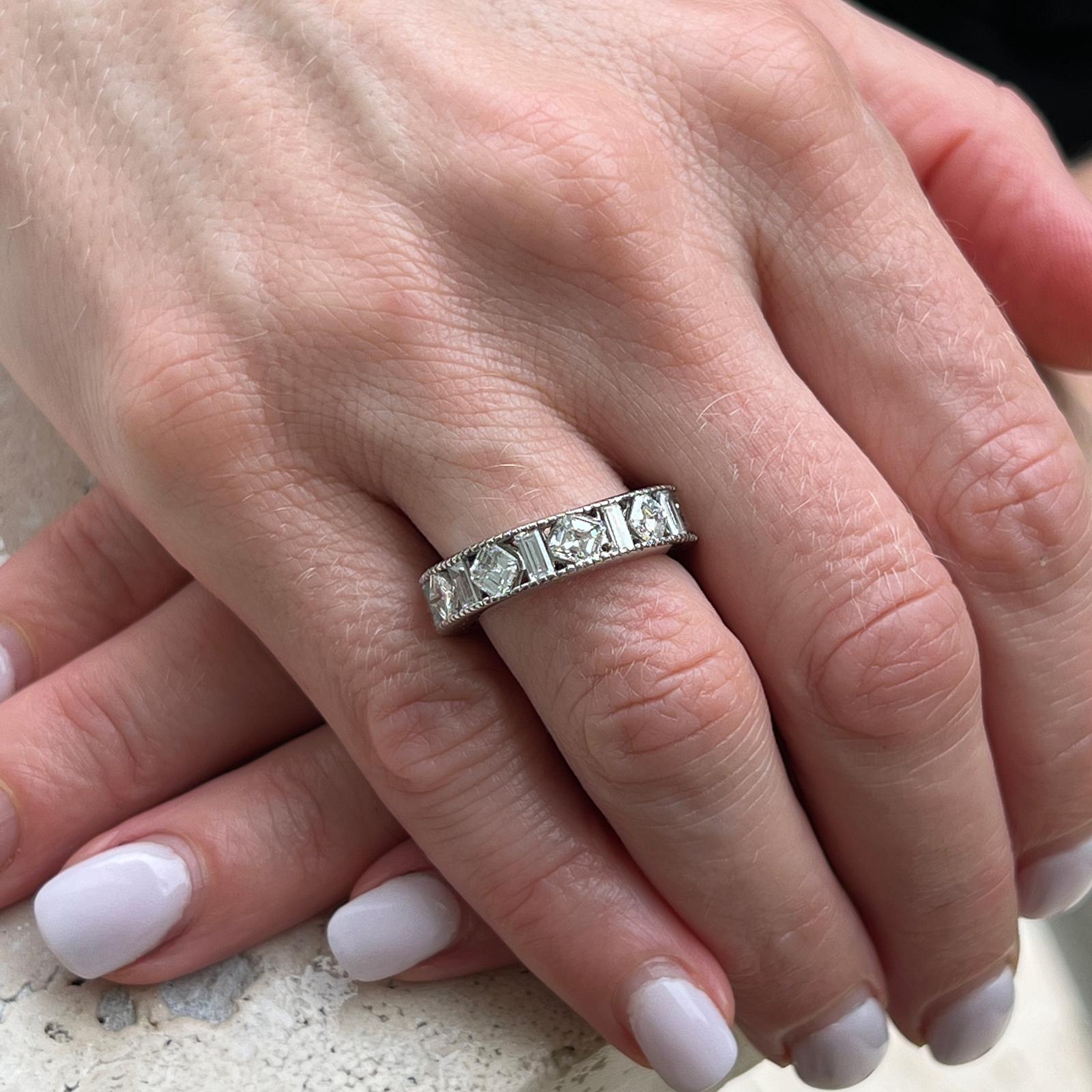 Fabulous diamond band handcrafted with milgrain edging in 18 karat white gold. The band features 6 square emerald cut diamonds weighing approximately 2.40 CTW and 7 baguettes weighing approximately 1.00 CTW (3.40 CTW). The diamonds are graded G-H