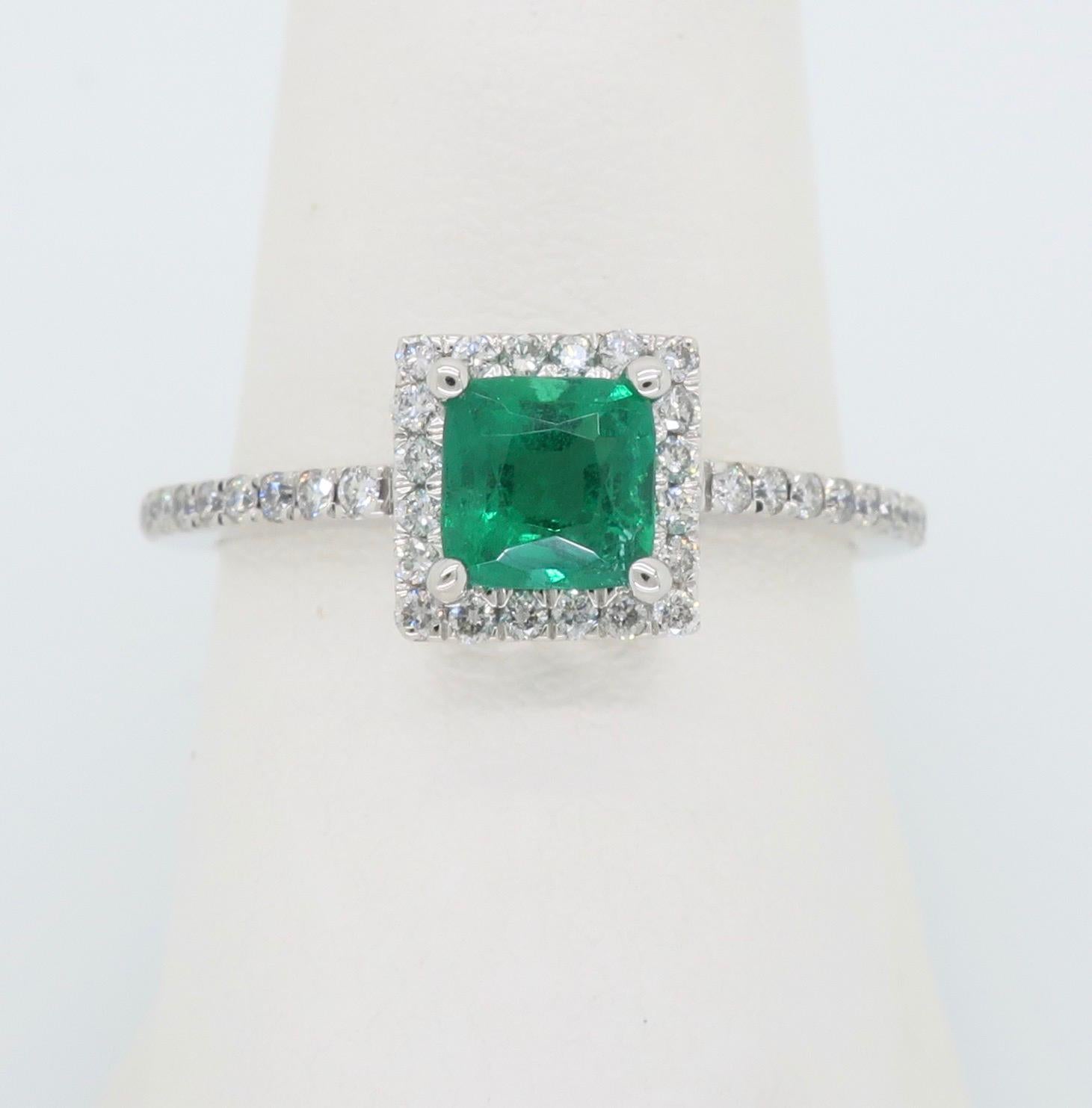Emerald and diamond halo style ring crafted in 14k white gold. 

Gemstone: Emerald & Diamonds
Gemstone Carat Weight:  Approximately .70CT 
Diamond Carat Weight:  Approximately .27CTW
Diamond Cut: Round Brilliant Cut
Color: Average G-I 
Clarity: