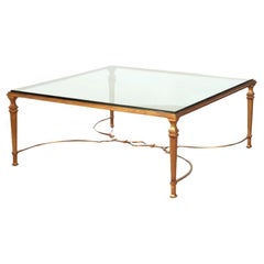 Table basse carrée en fer doré et plateau de verre