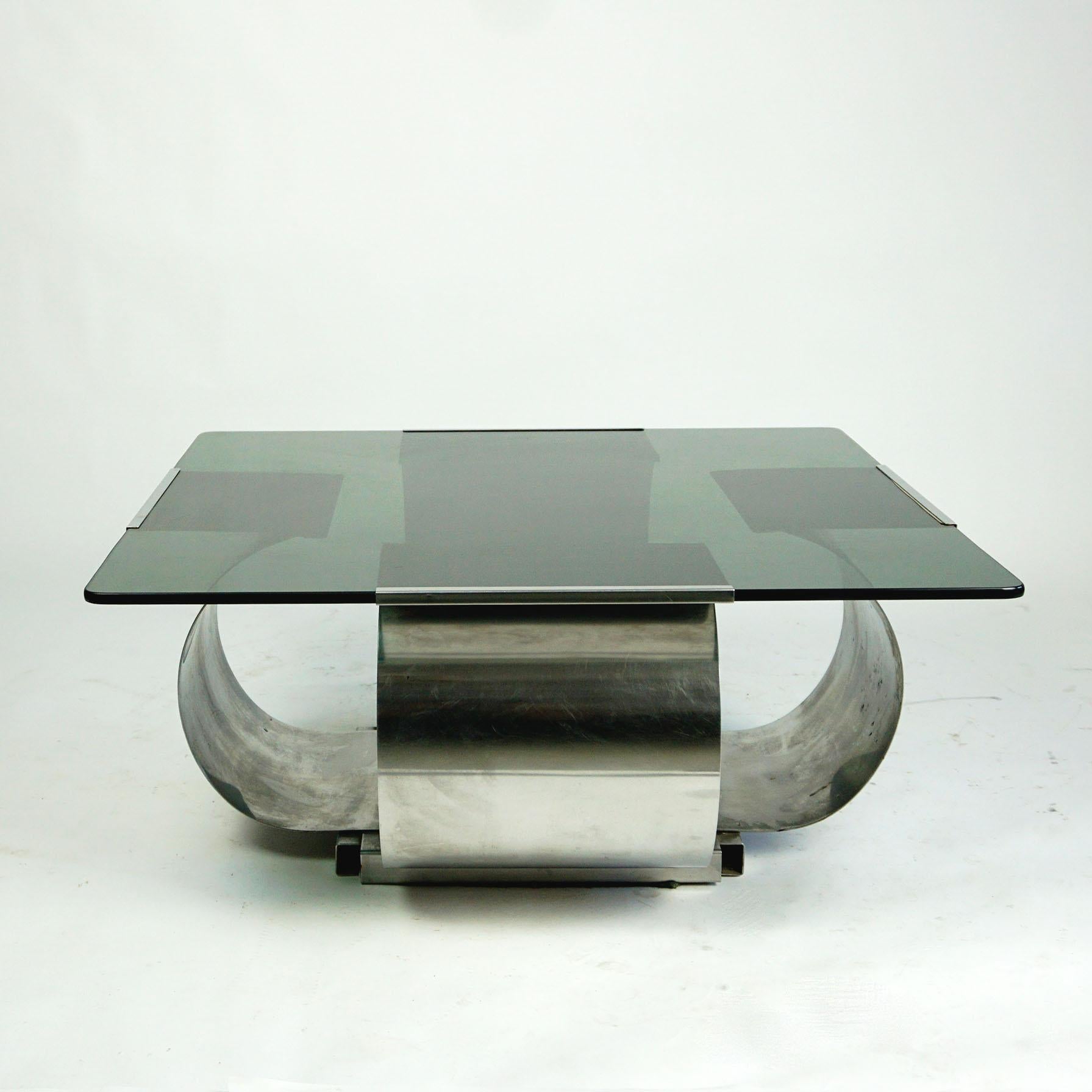 This eye catching smoked glass and brushed steel square coffee table was designed by Francois Monnet in the 70s and produced in France. It features a steel corpus with a smoked glass top and is in very good condition. 
It will be the perfect