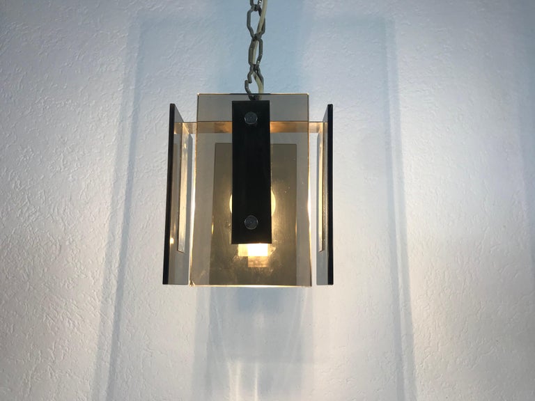 A beautiful square glass hanging lamp made in Italy in the 1970s. The light is made of thick glass. It has an amazing transparent color and it is very solid. The four glass parts are secure to the body with two aluminium screws. The top of the lamp