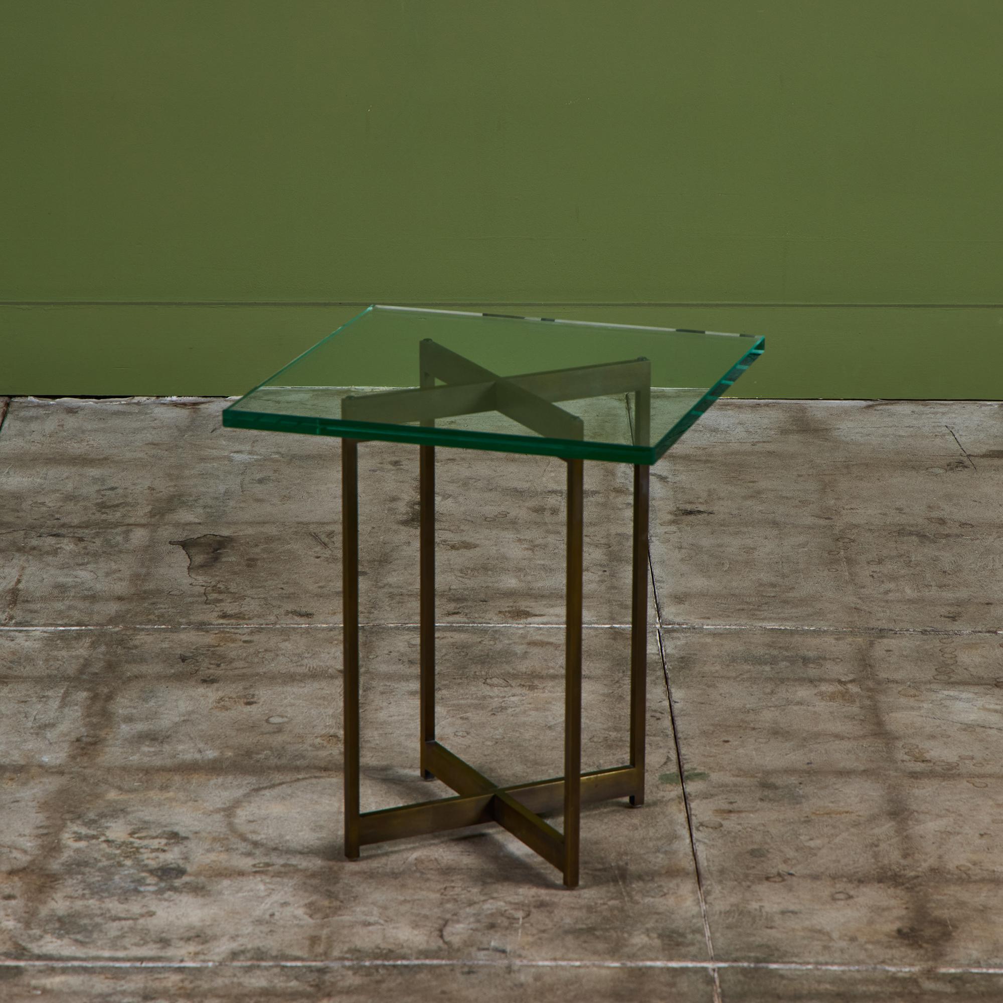 Table d'appoint carrée en verre de Metropolitan Furniture, basé à San Francisco, CA, vers les années 1970. La table est composée d'une épaisse pièce de verre carrée qui repose sur un cadre en laiton patiné à base en x.

Dimensions
17,75