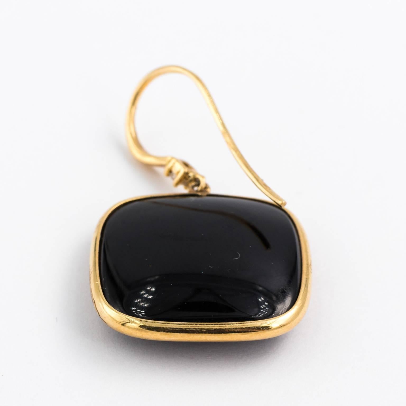 Modern 18 karat gold, French wire faceted onyx earrings with 10 carat diamond on top of square.