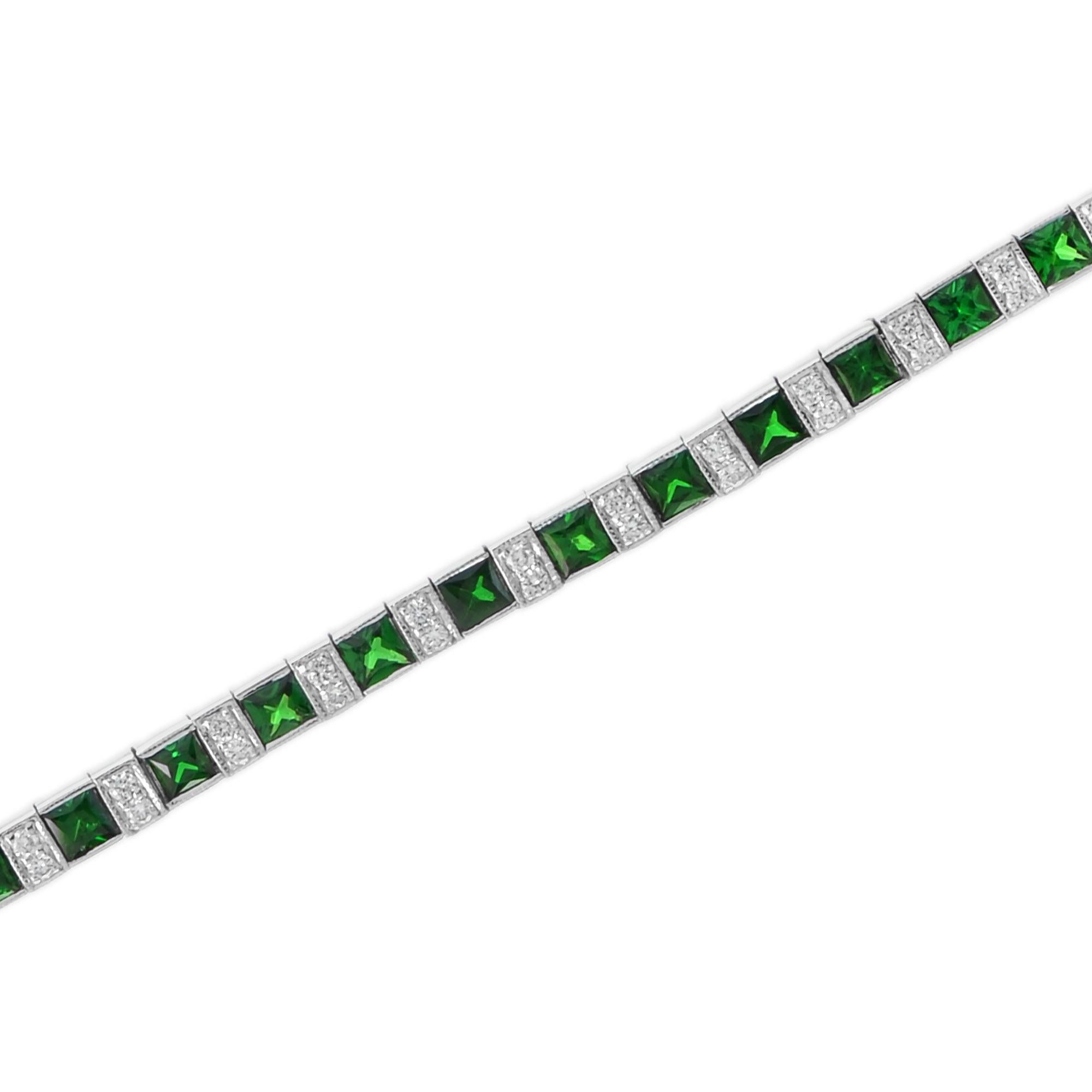 Un classico senza tempo che ogni donna dovrebbe possedere. Questo bracciale presenta diamanti rotondi taglio brillante e tsavorite taglio principessa in oro bianco. È un bracciale tennis classico ed elegante, perfetto per tutte le occasioni. Oro