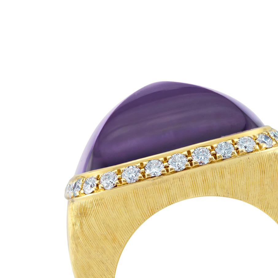 A square special hand curved hair line cabochon amethyst surrounded by glistening round brilliant cut diamonds. The cabochon amethyst is this gorgeous purple and violet shade with mystifying dark tints. The band itself is a chunky thick 18 ct yellow