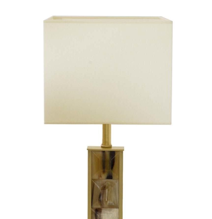 The unique color combination of the light-toned Horn and satin-finished brass creates visual harmony to this timeless and elegant table lamp. Raised on a square base, the body of the lamp is enriched with squares handcrafted of natural Horn, whose