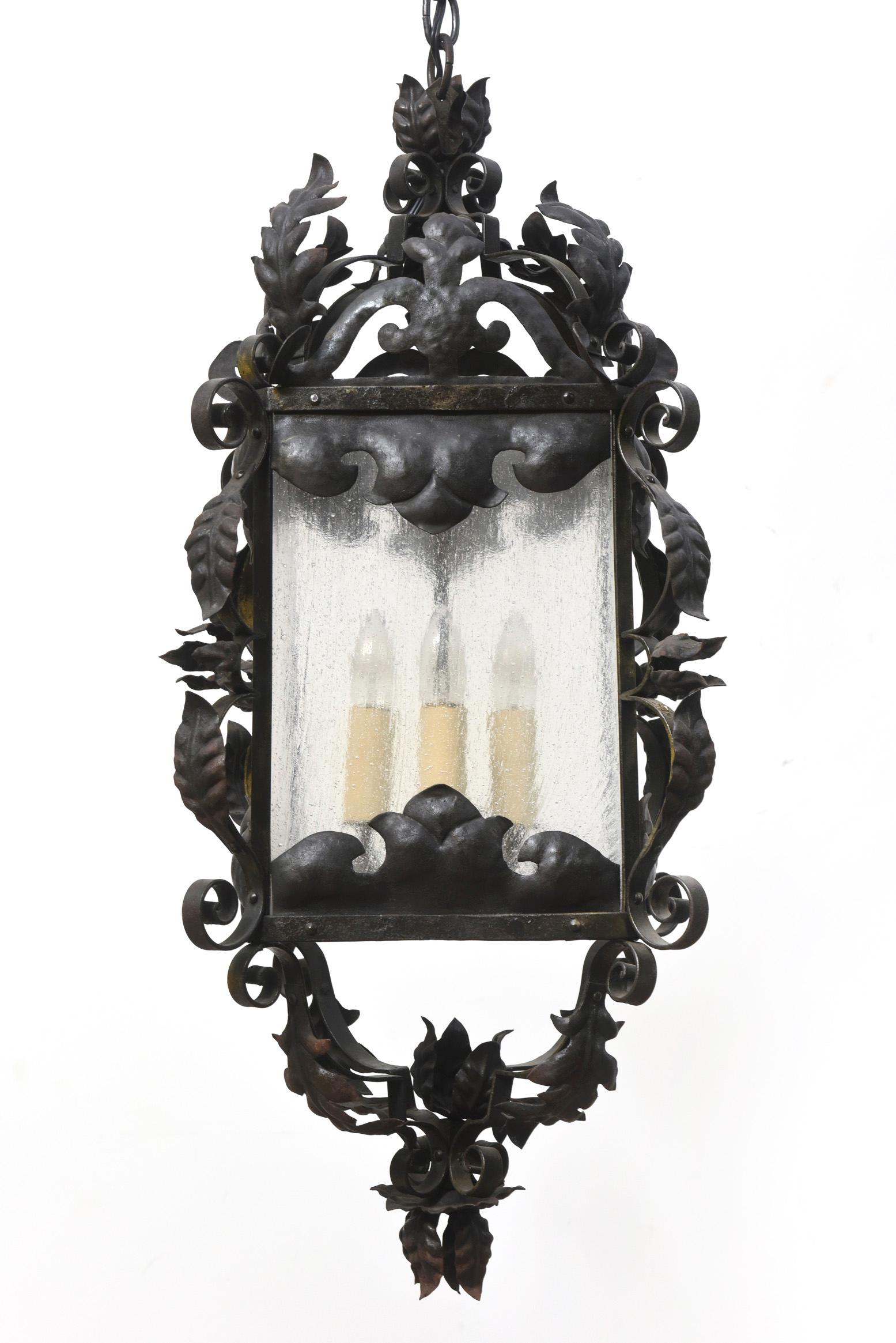 Italian ornate wrought iron lantern with original antique black painted finish and four seedy glass panels. Interior Use only. Four lights. Completely restored and rewired, ready to hang. Italian, C. 1900.