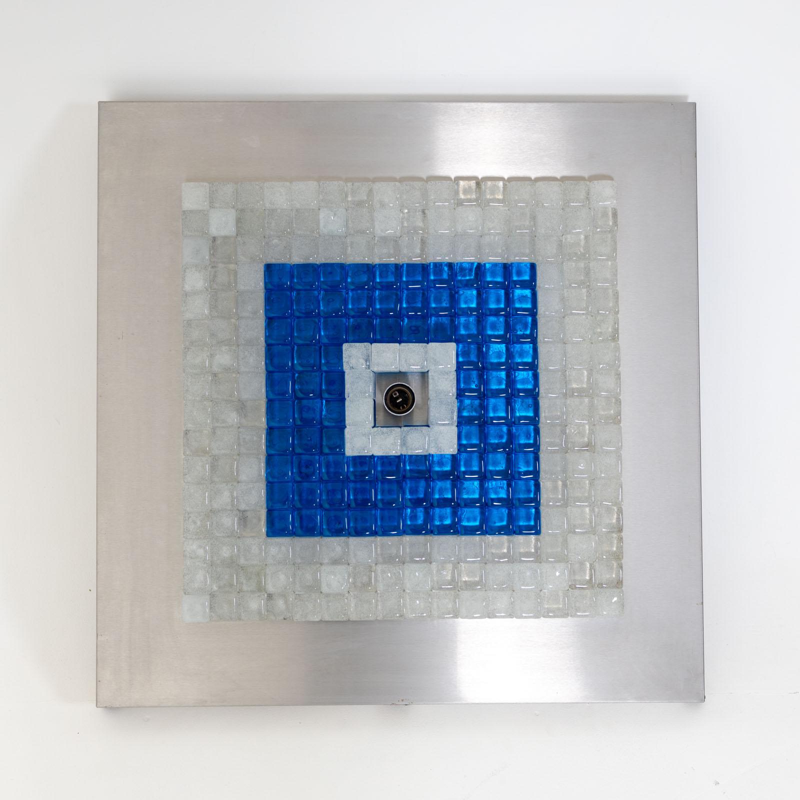 Quadratische Decken- oder Wandleuchte, entworfen von Albano Poli für Poliarte in den 1970er Jahren. Die Leuchte besteht aus einem Metallrahmen mit kleineren Quadraten aus blauem und klarem Glas, die um eine zentrale Fassung gruppiert sind.