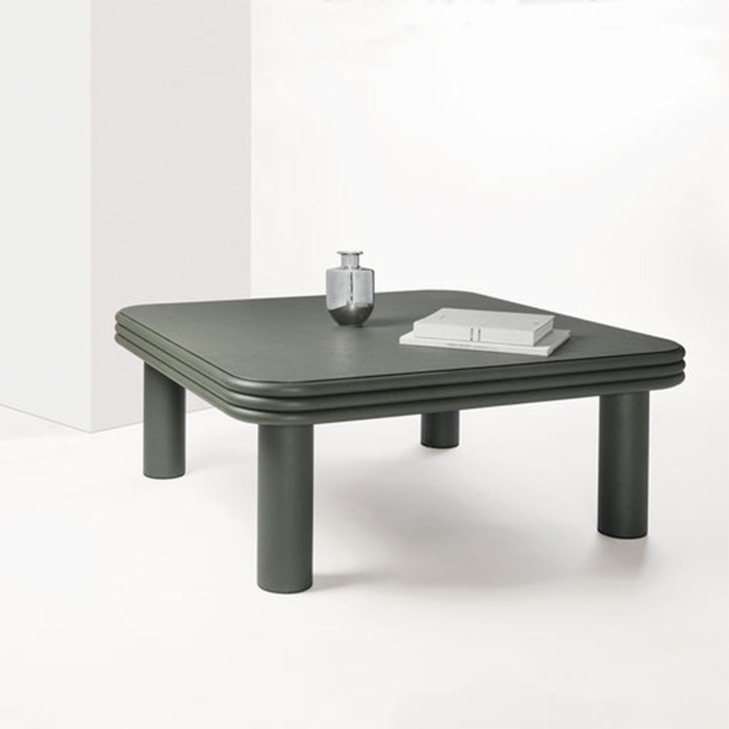 Contemporary leather square coffee table - Scala by Stephane Parmentier for Giobagnara.
The object presented in the image has following finish: F02 loden green nappa leather.

Supported by four thick cylinders and entirely covered in dark green