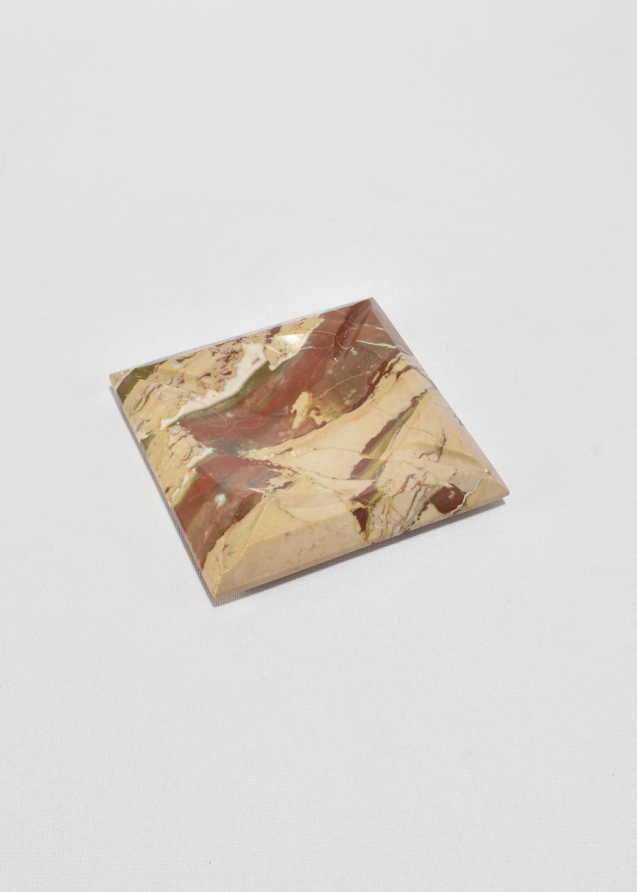 Striking mid-century ashtray carved from richly veined multicolor marble. Four sharply faceted pyramidal corners frame a gently sloped center, with slots for resting cigarettes. A bold sculptural object, equally suited for display, use as an