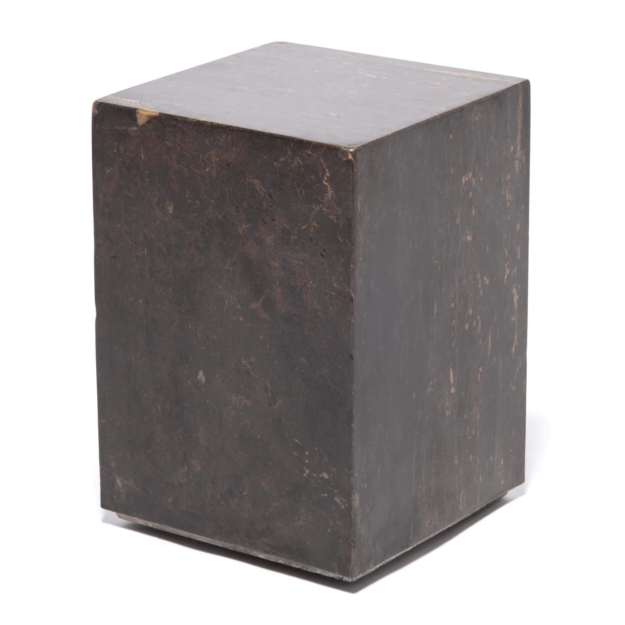 The design of this contemporary doon table makes its solid marble form appear to float off the ground. Hand-carved into a marble block, the base has a graceful reveal, giving the stone a modern lightness. The table's rich, dark color is swirled with