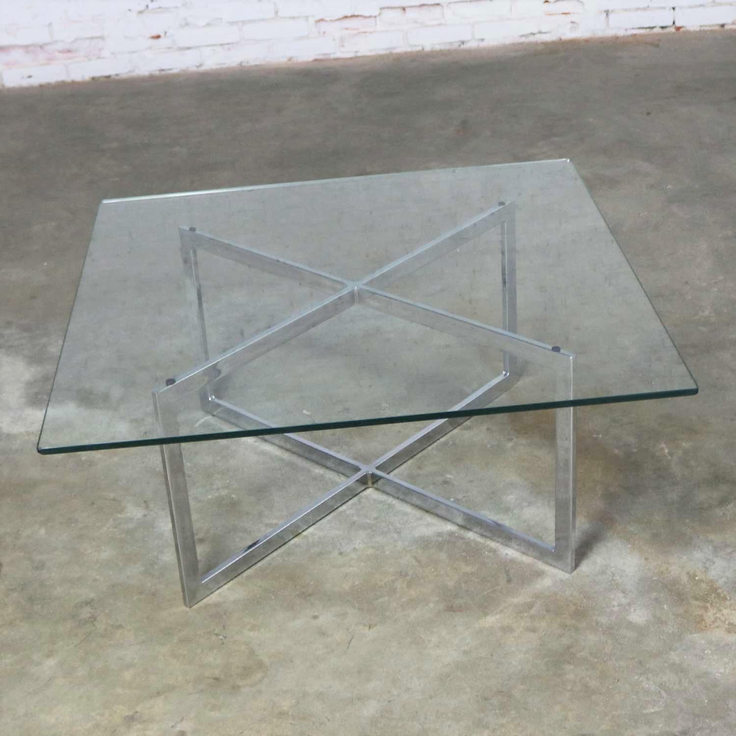 Handsome square coffee table with a rectangular tube chrome X-base and 3/8 inch glass top. Unmarked but styled after Milo Baughman. Although, we do have the original sales receipt for this table from Tri-Mark Designs in Philadelphia dated January