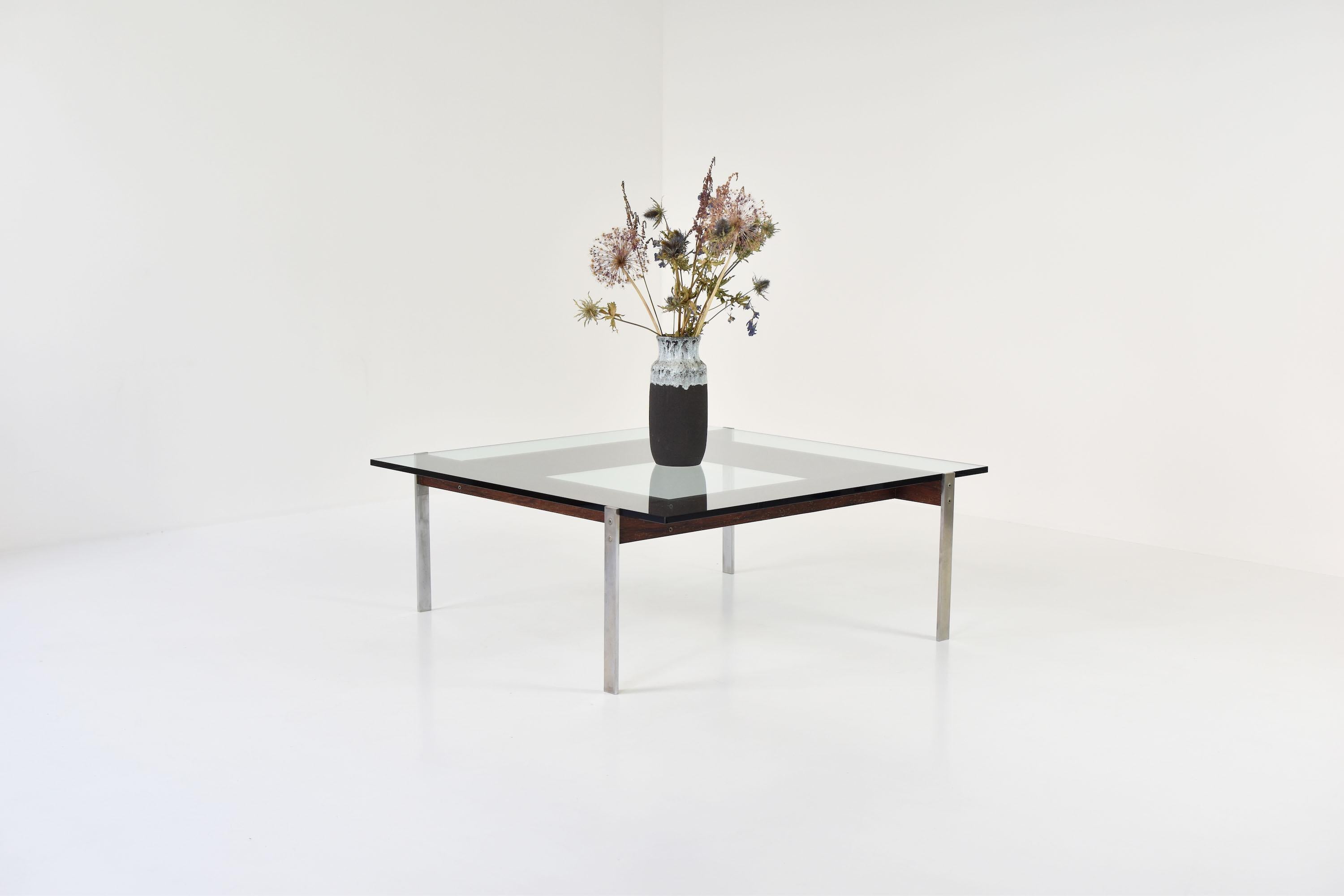 Elegant square Modernist coffee table by (for now) unknown designer or manufacturer. The polished steel frame is partially veneered with rosewood, giving the table an extra touch. The removable glass table top is renewed. Four base elements are
