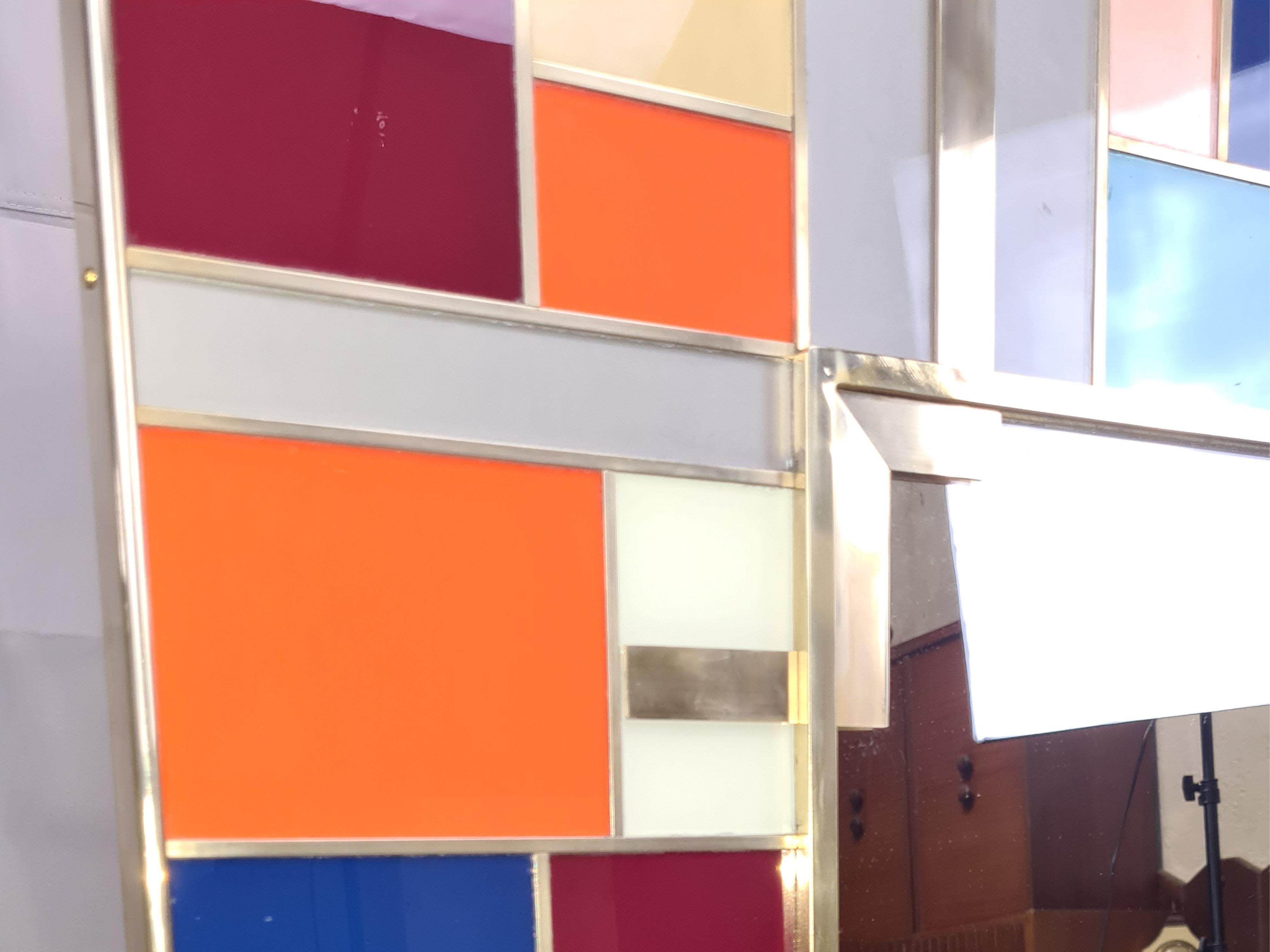 Multicolor Murano glass wall mirror, a masterpiece of modern style and Italian artistic tradition. 

Handcrafted in Italy, this mirror features more than 60 meticulously cut pieces of authentic Murano glass, each separated by custom-made brass