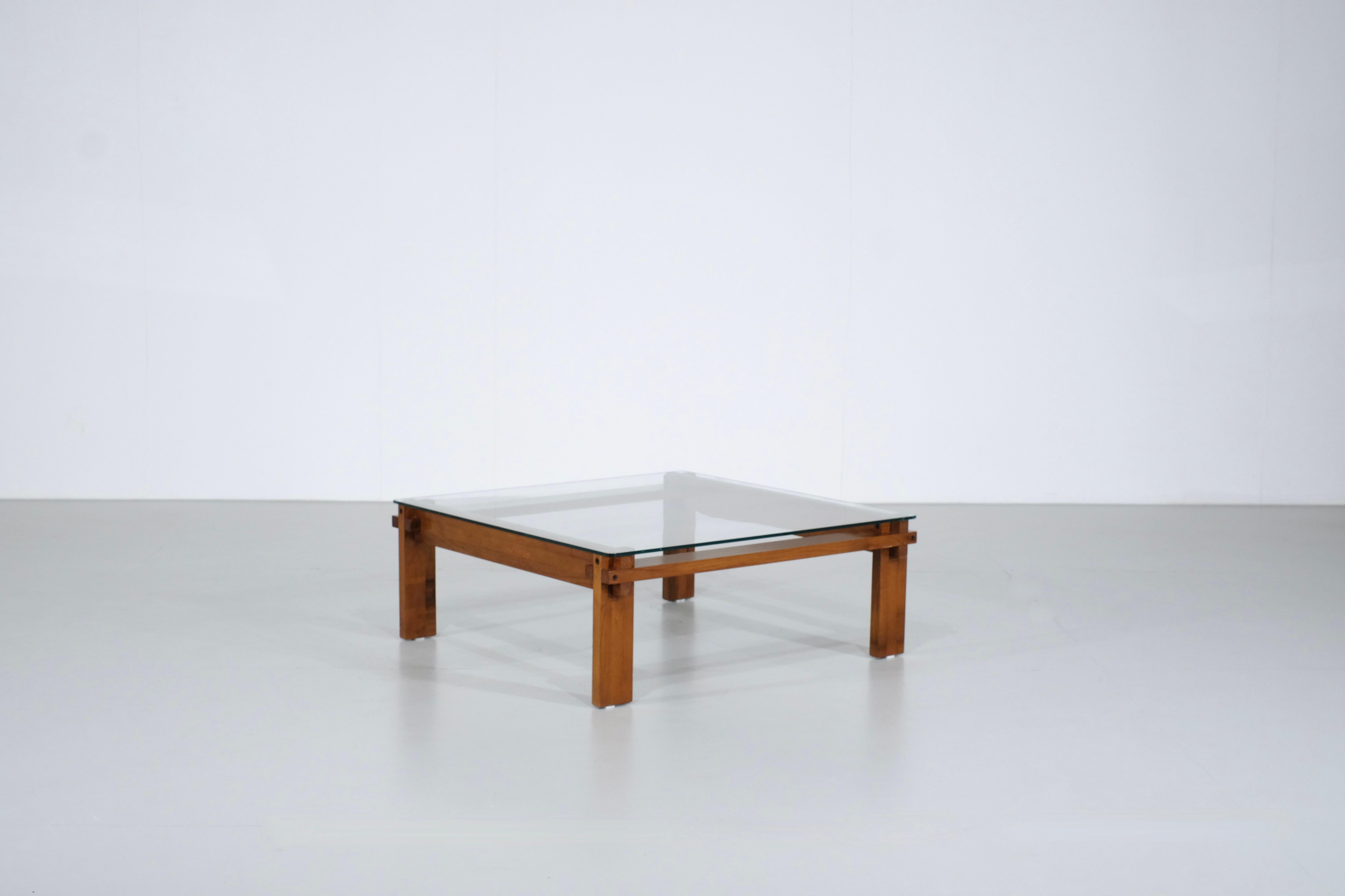 Magnificent square oak coffee table designed in the 1970s.

The uniqueness of this table lies in the way the corners are assembled. It also features a glass plate placed on the frame.
The work is beautifully done.

This table is in very good vintage