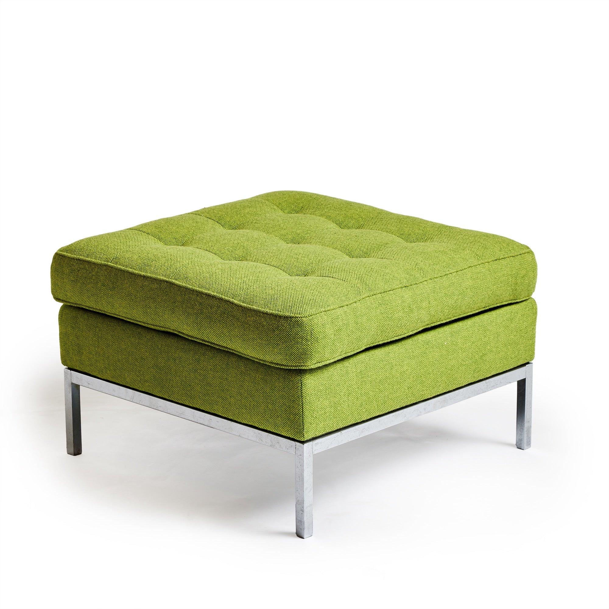 Un semplice pouf quadrato con una base cromata e una seduta e un cuscino imbottiti di recente in verde lime.